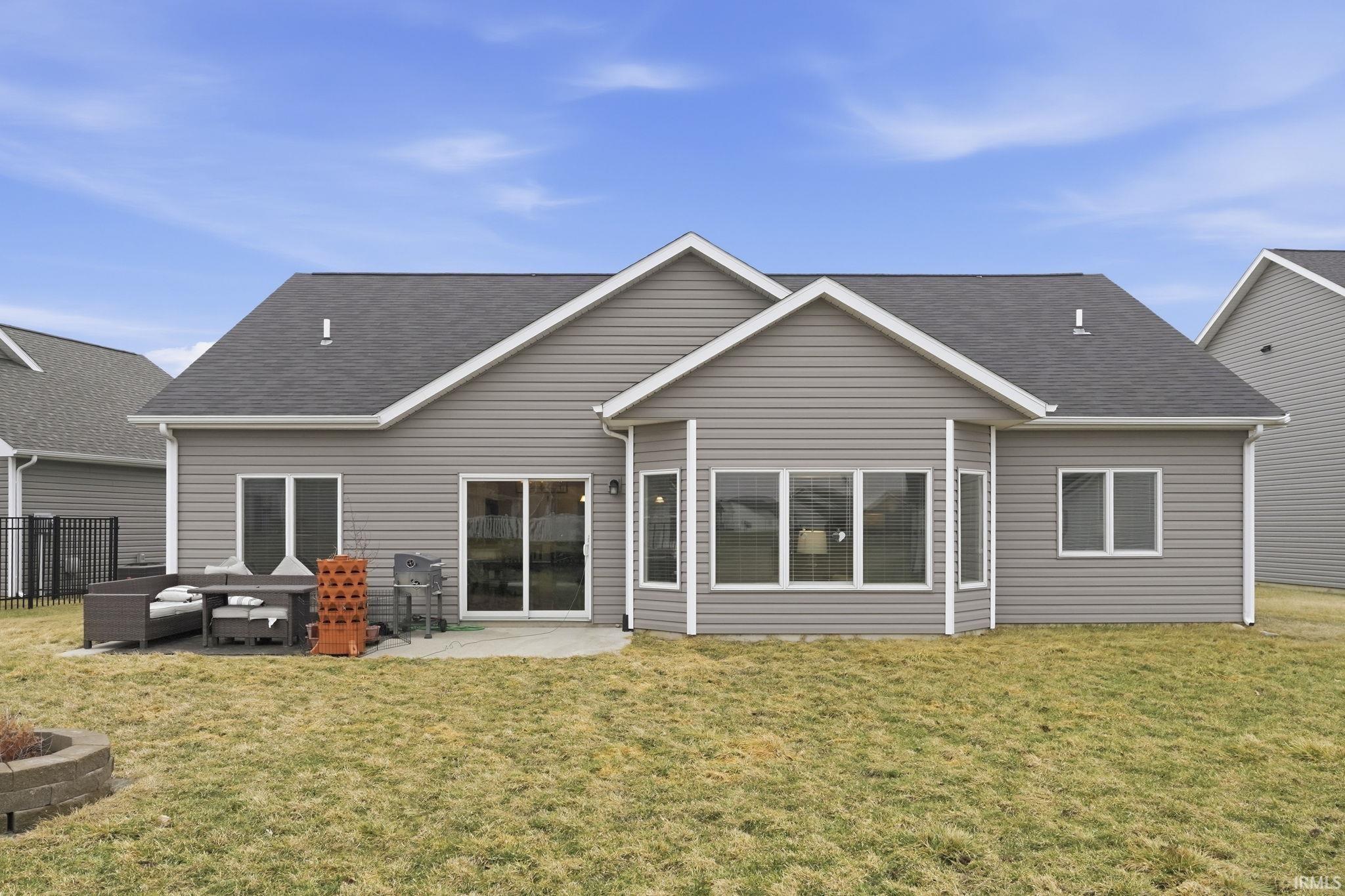 Back of property with a patio and a shingled roof