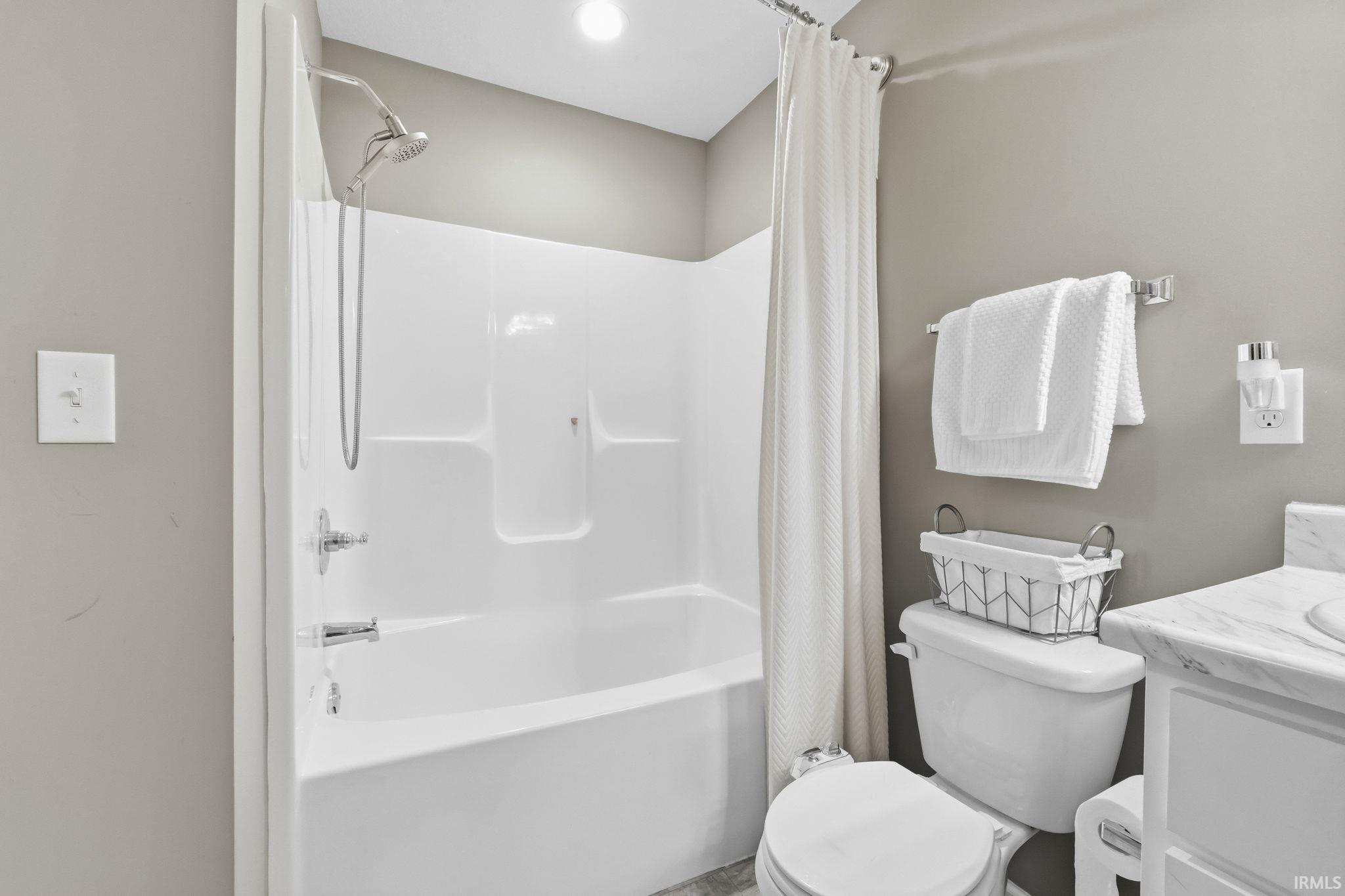 Bathroom with vanity and shower / bath combination with curtain