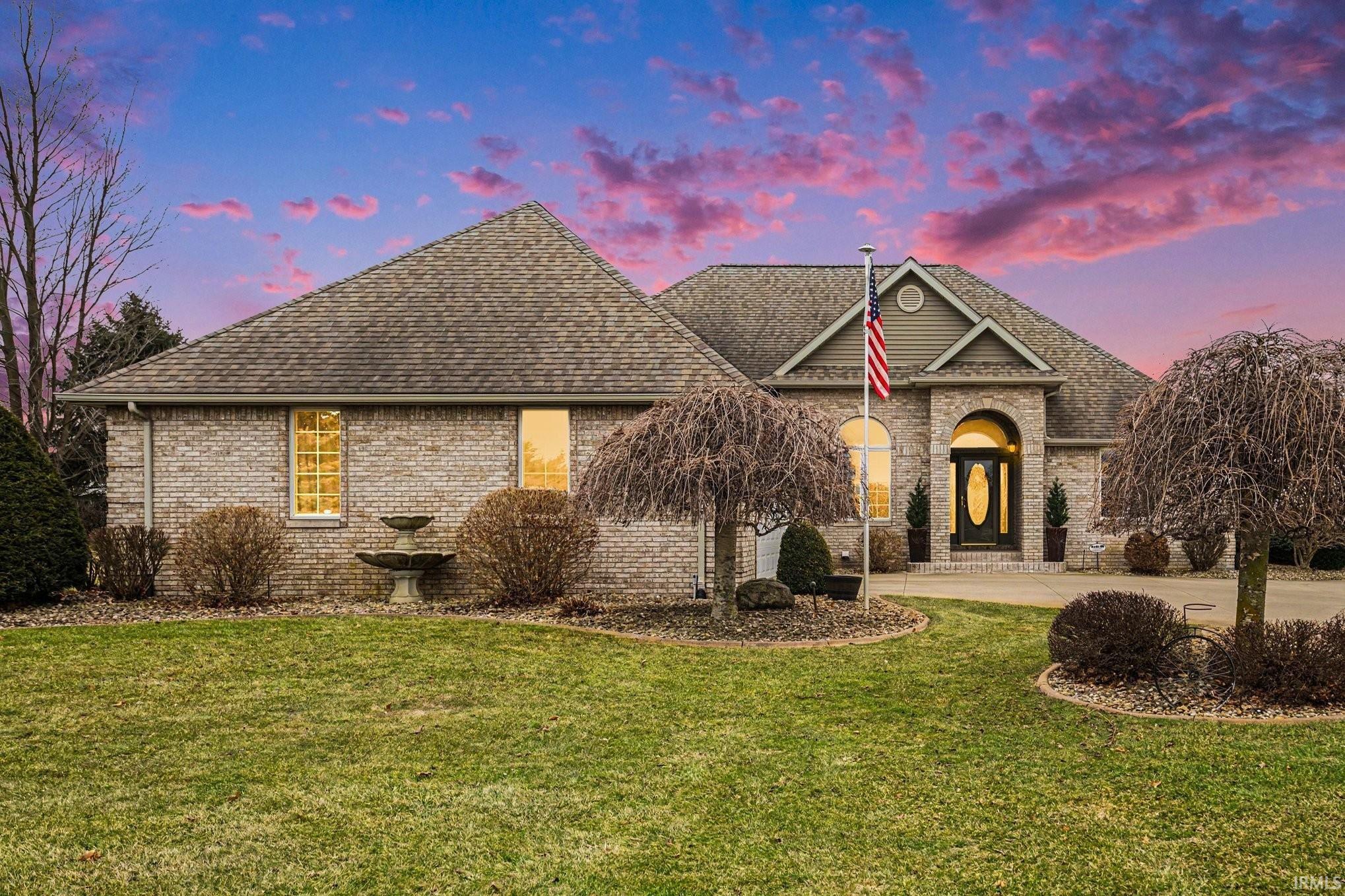 View of front of house featuring a front yard, brick siding, concrete driveway, and a shingled roof