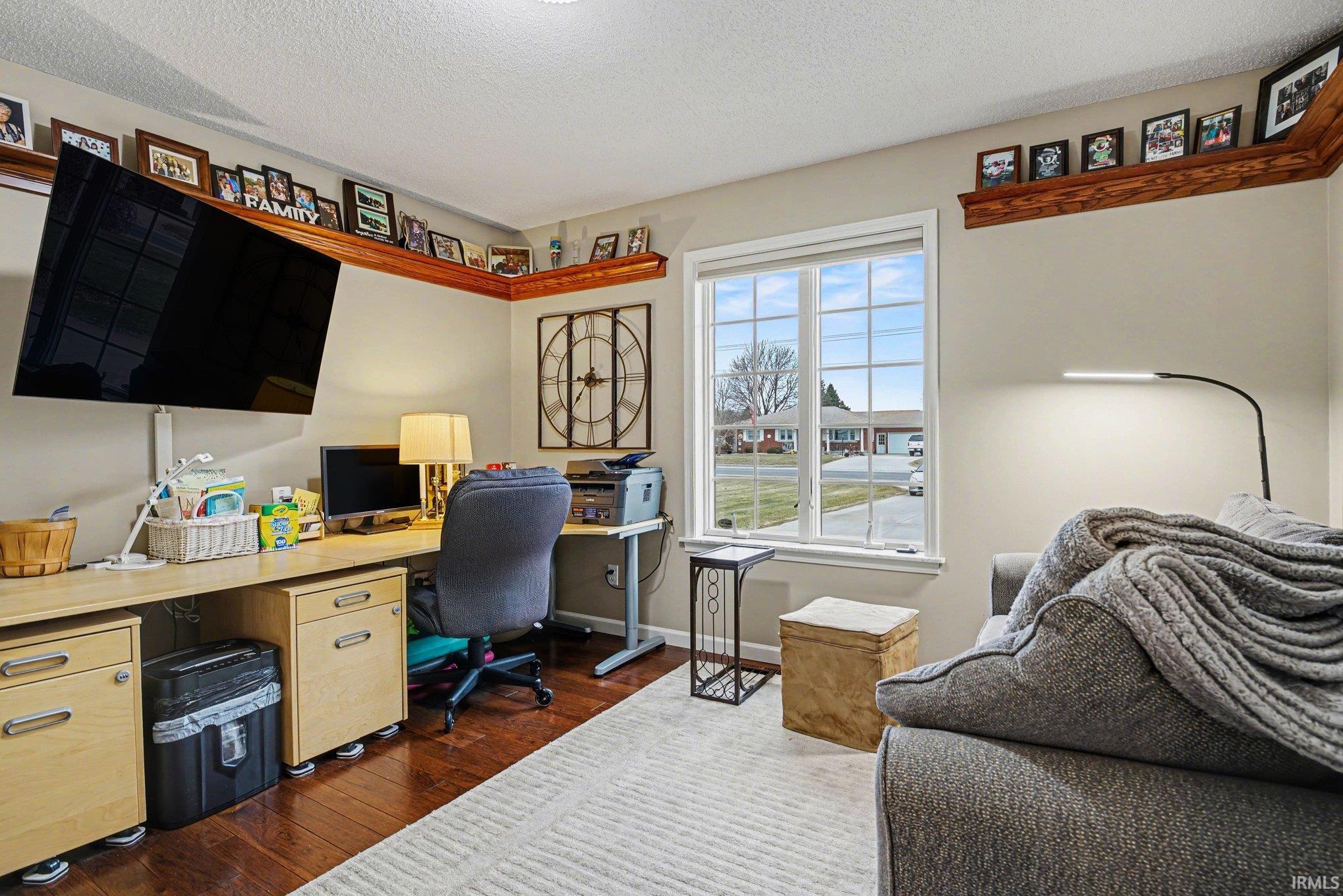 Office area featuring dark wood finished floors and a textured ceiling