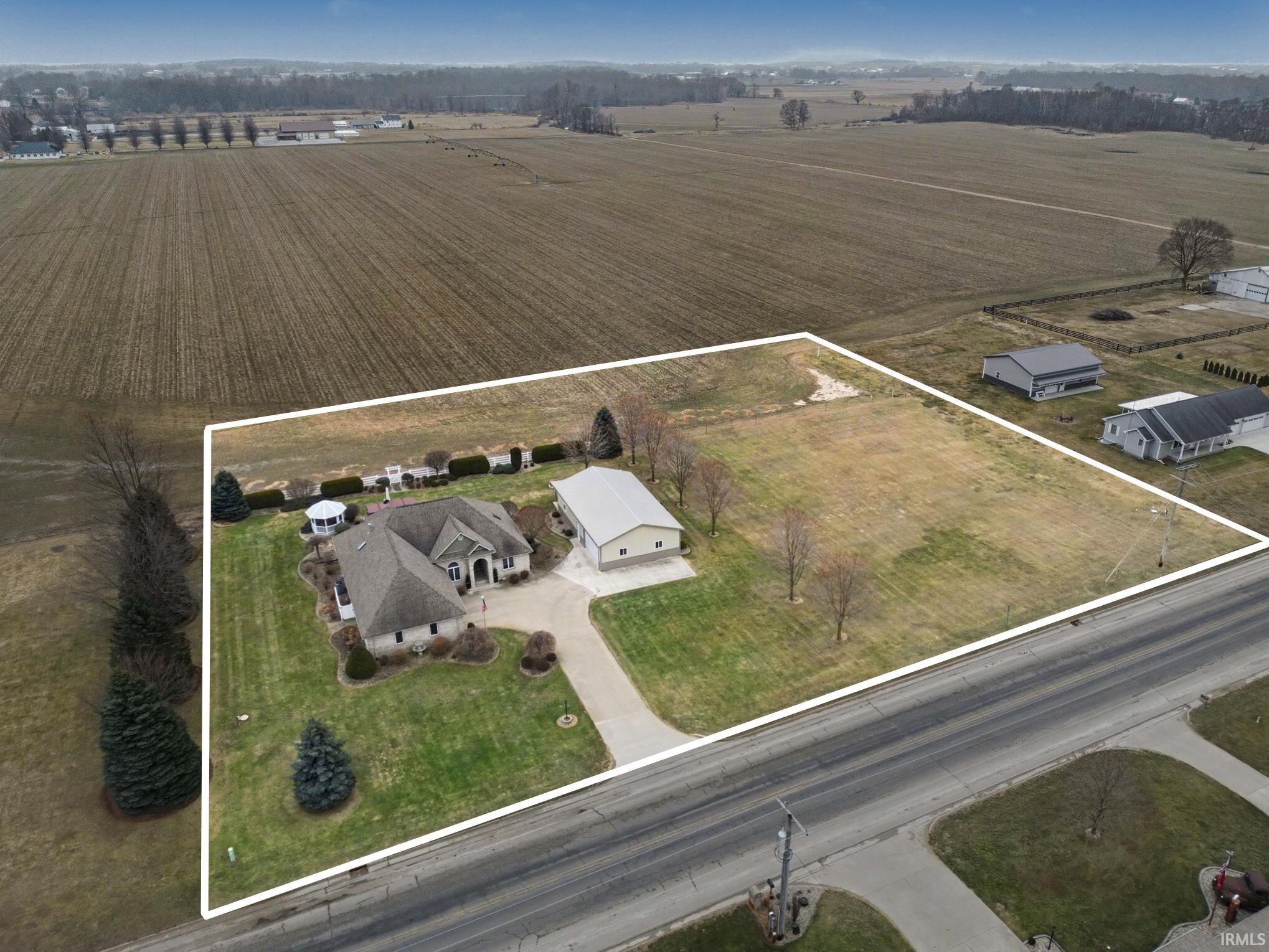 Aerial view of sparsely populated area featuring property parcel outlined and large plots for crops