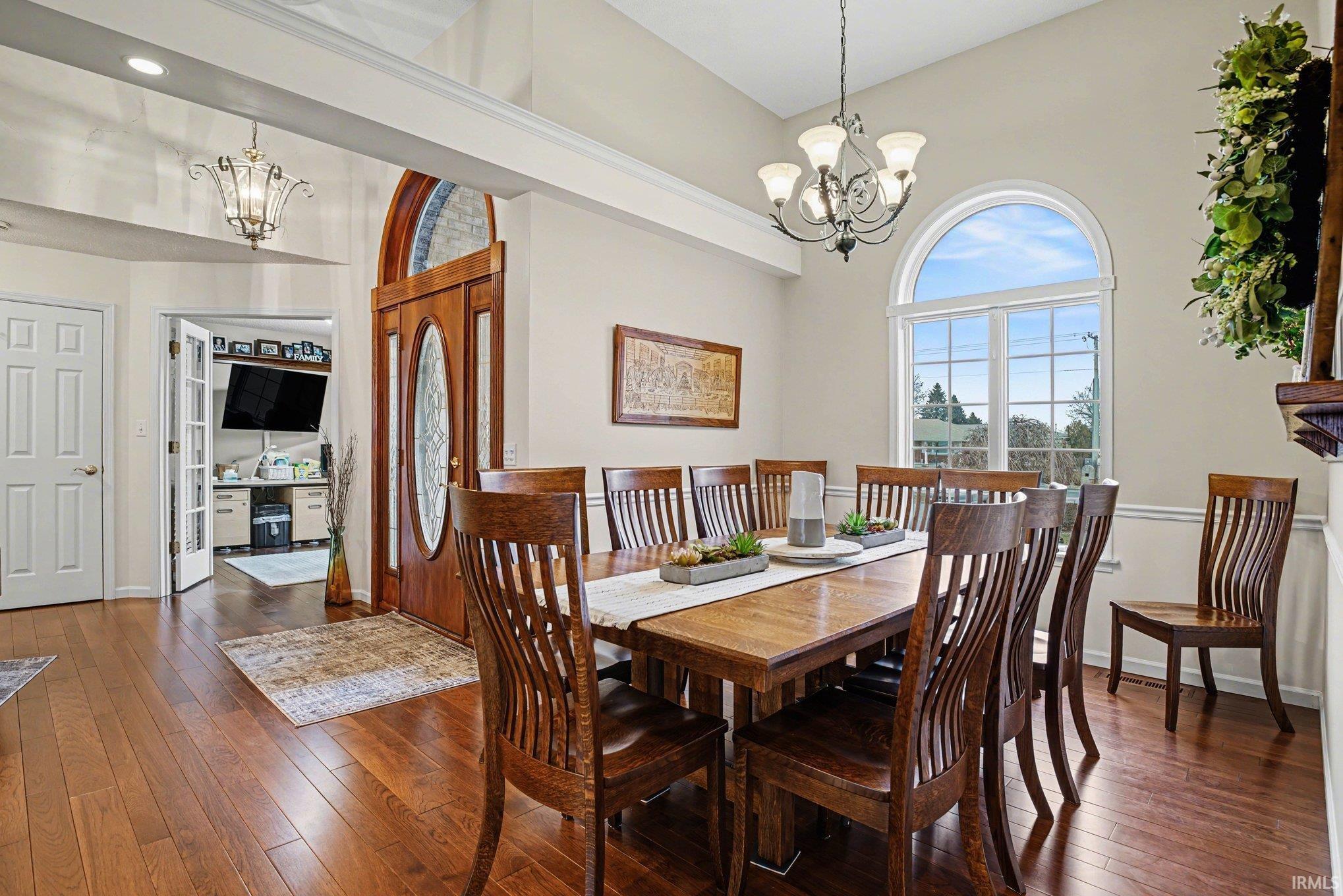 Dining room featuring suspended lighting, dark wood-style floors, and lofted ceiling