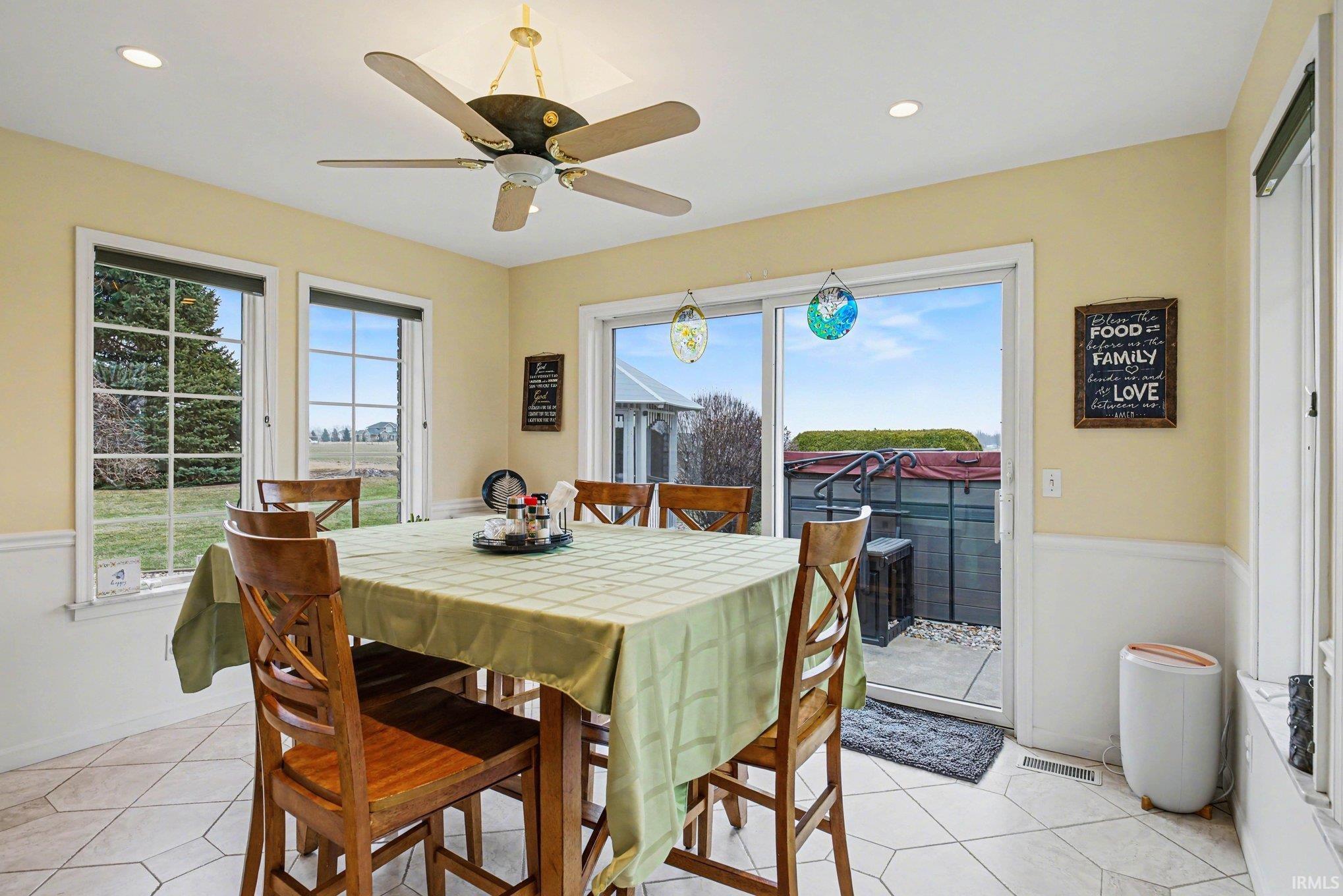 Dining space featuring healthy amount of natural light, light tile patterned floors, a ceiling fan, and recessed lighting