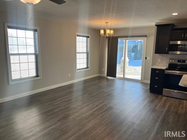 Kitchen with stainless steel appliances, light countertops, dark cabinetry, and healthy amount of natural light