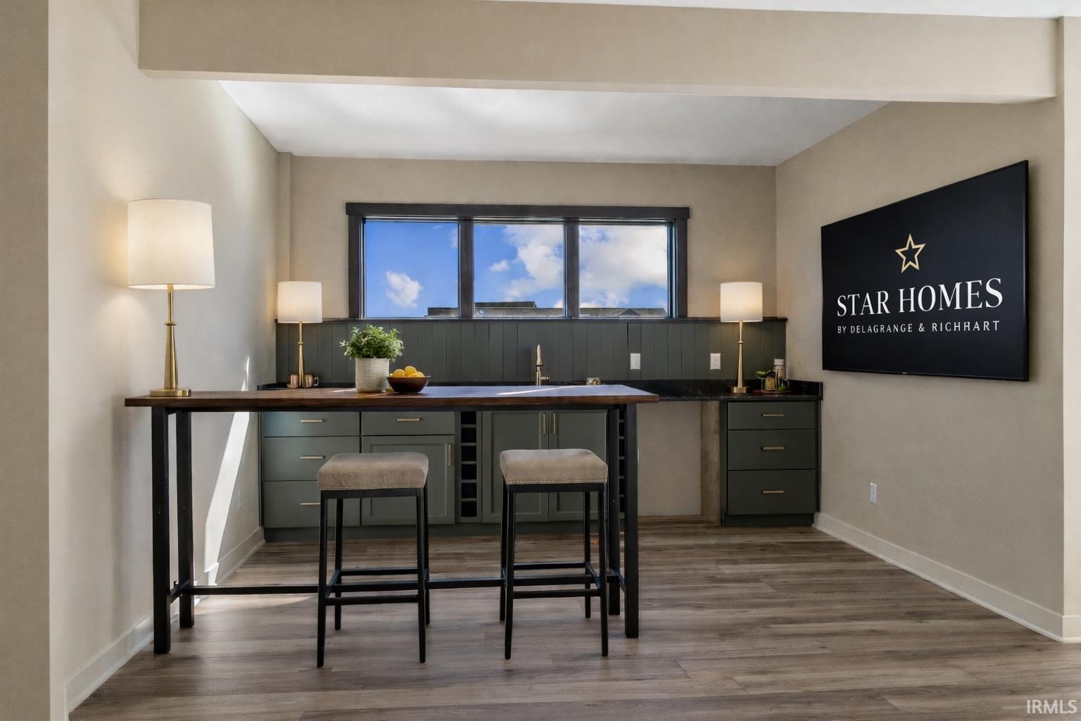 Bar with dark wood-style flooring and baseboards