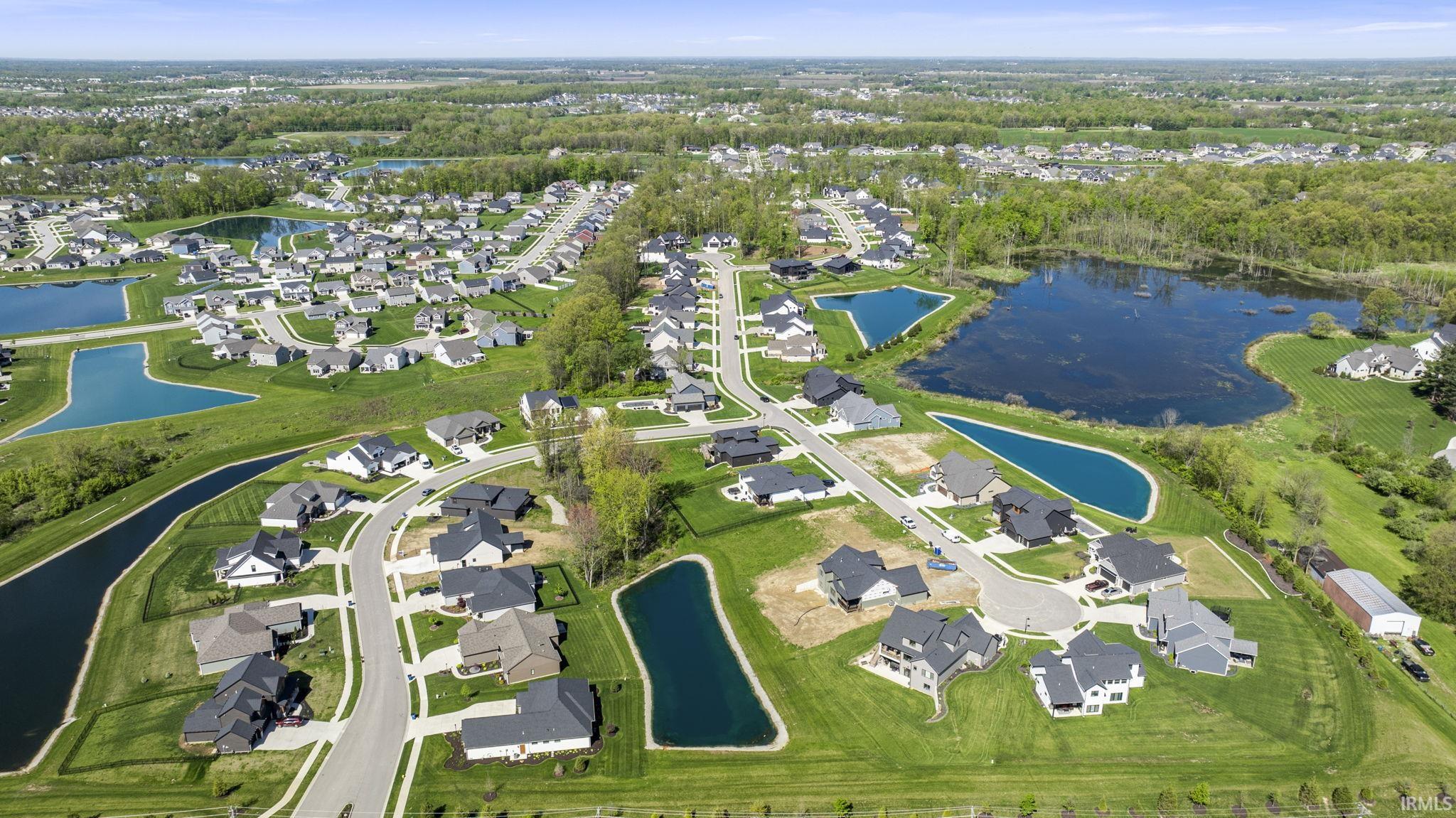 Aerial view of property and surrounding area with nearby suburban area and a nearby body of water