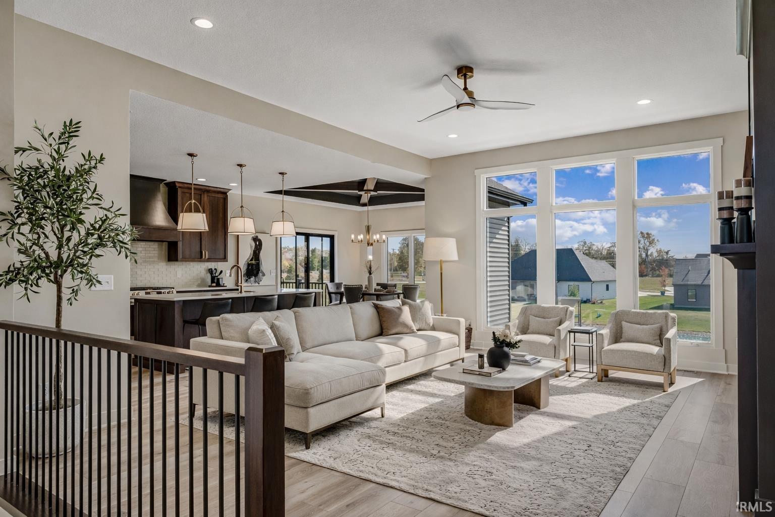 Living area with ceiling fan, light wood-type flooring, and suspended lighting