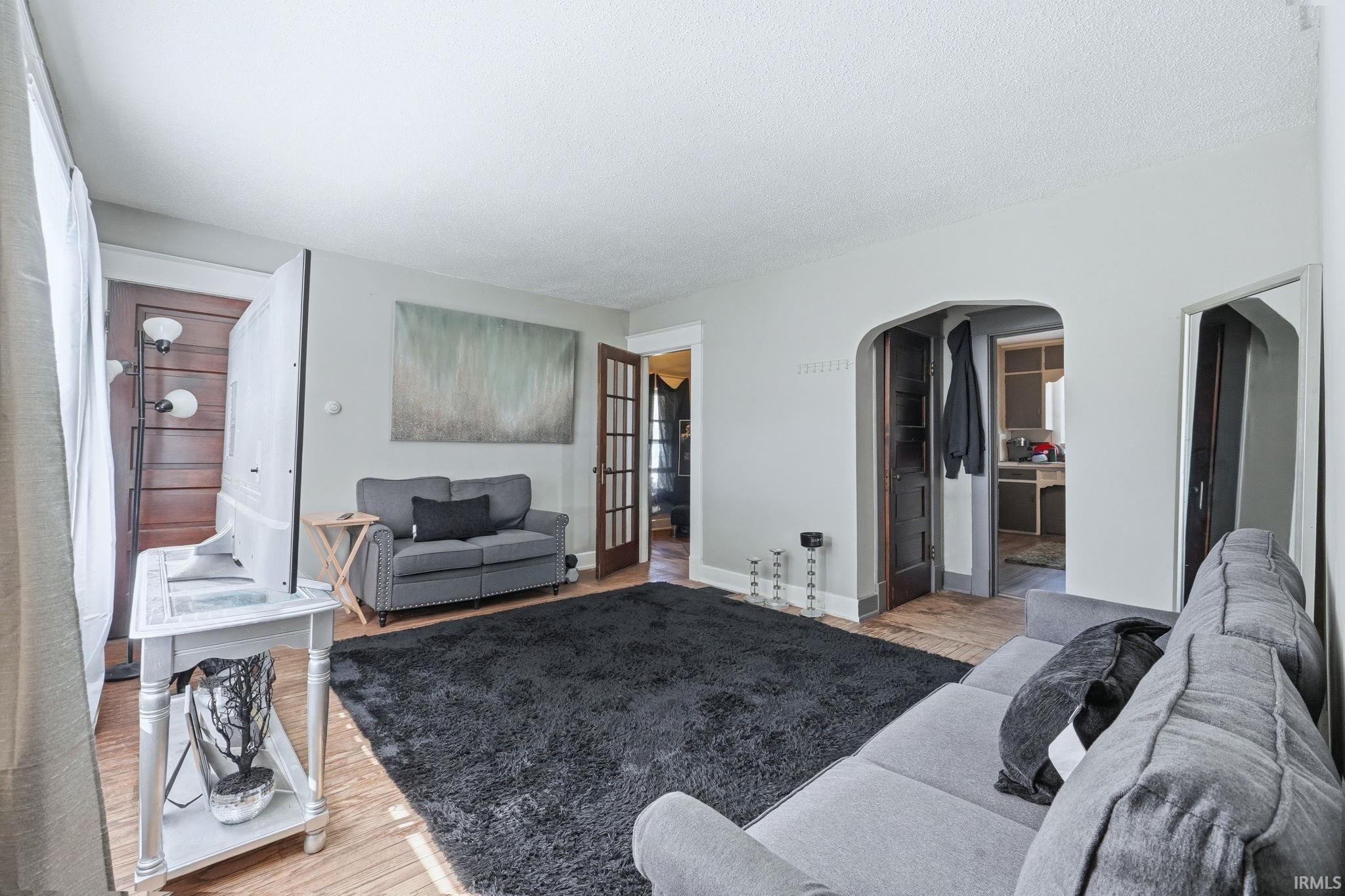 Living room featuring light wood-style flooring and arched walkways