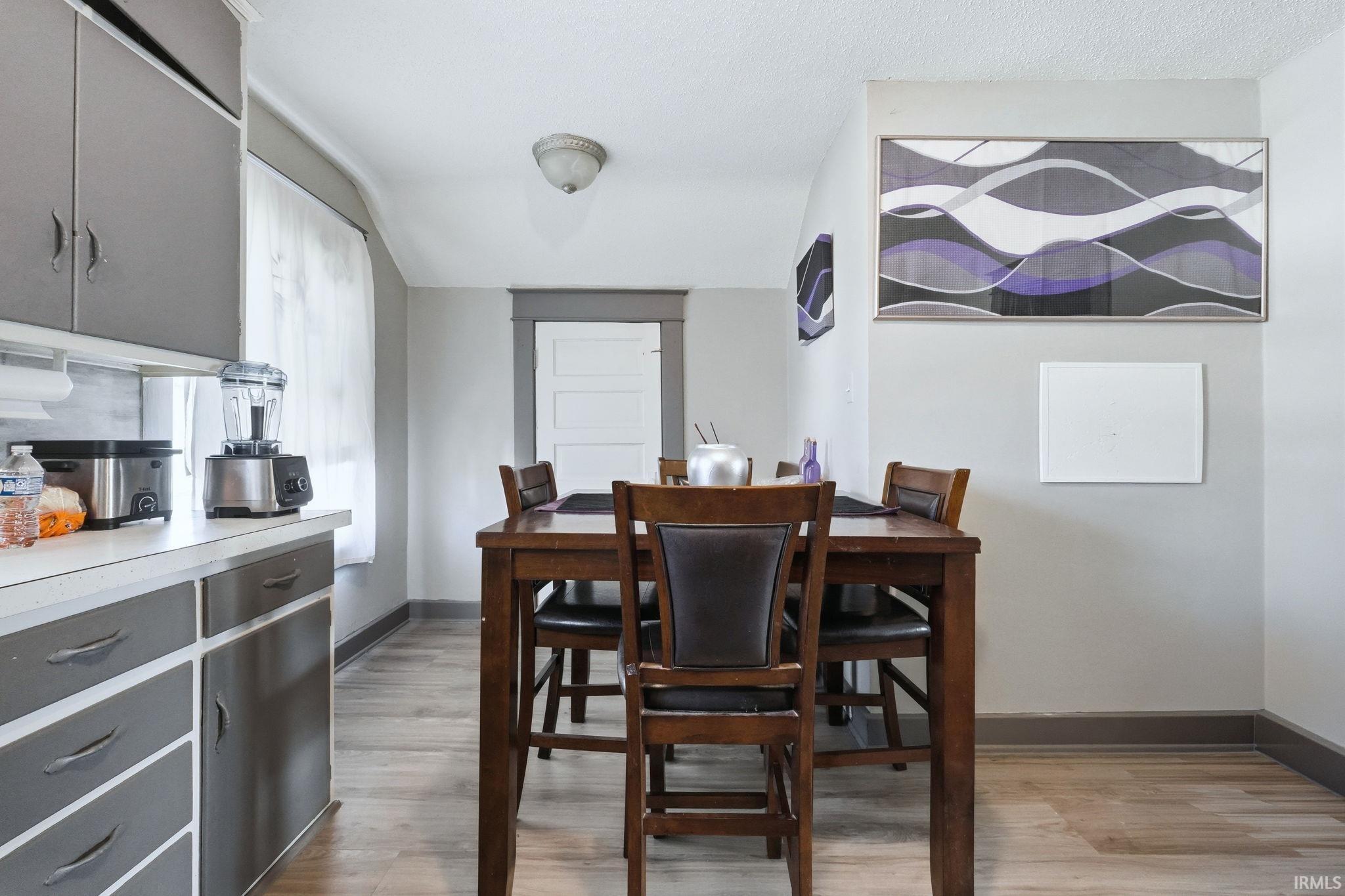 Dining area featuring light wood-style flooring and baseboards