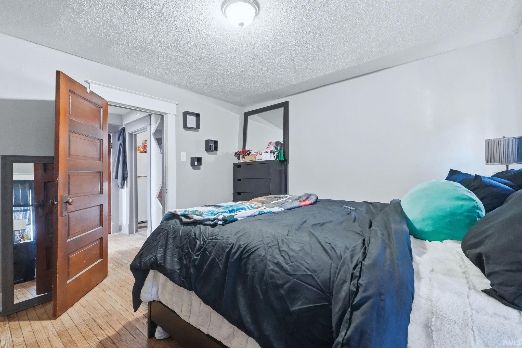 Bedroom featuring a textured ceiling and light wood-type flooring
