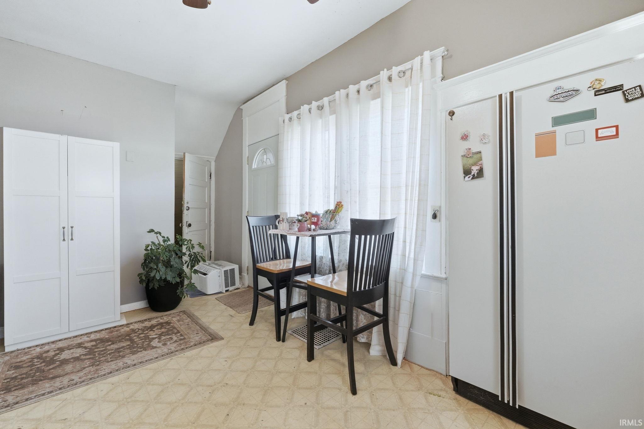Dining area featuring light flooring, vaulted ceiling, and a ceiling fan