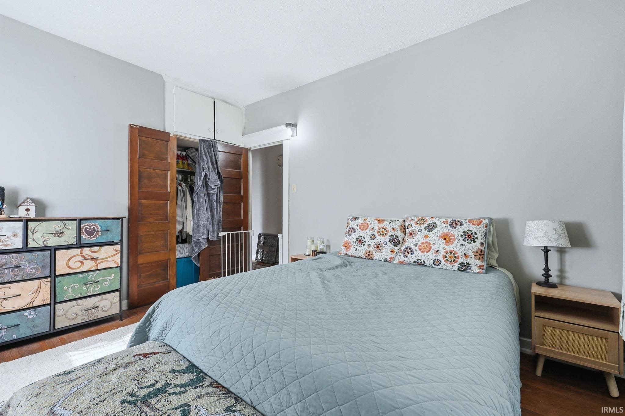 Bedroom with a closet and dark wood-style flooring