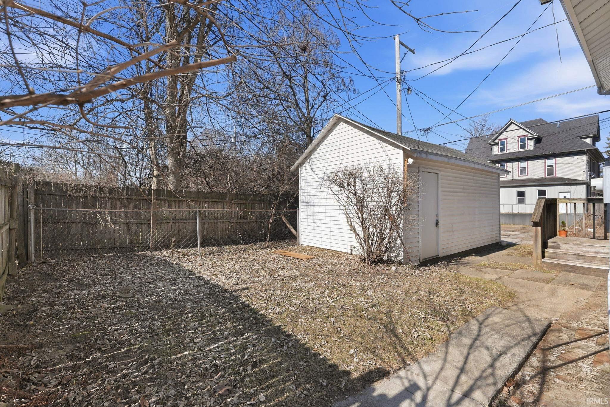 Fenced backyard featuring a shed