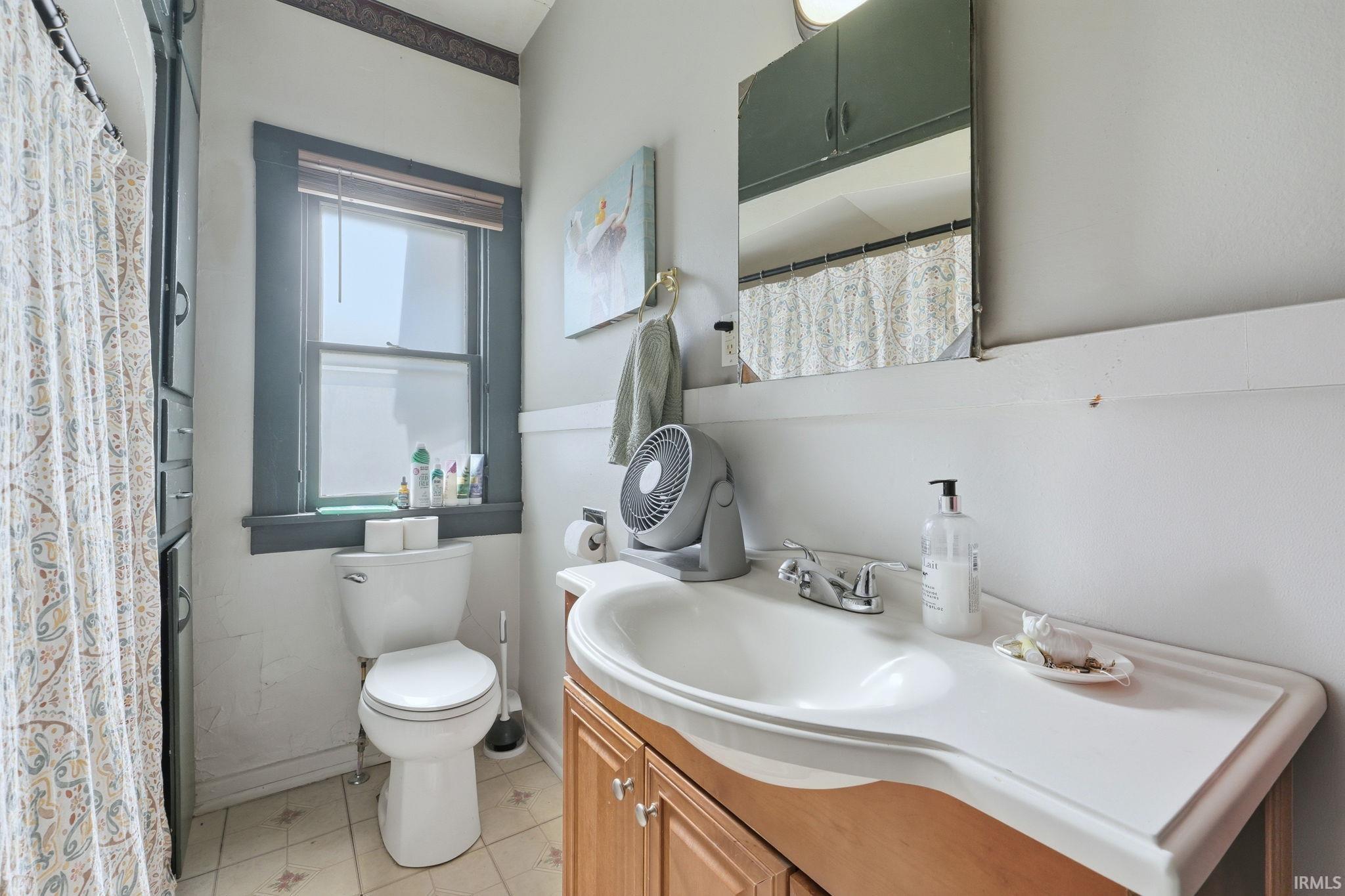 Bathroom featuring curtained shower and vanity