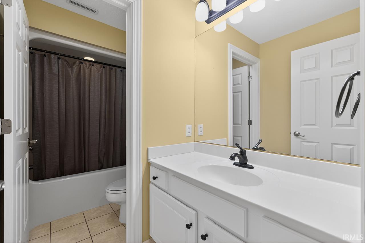 Bathroom with vanity, light tile patterned floors, and shower / tub combo