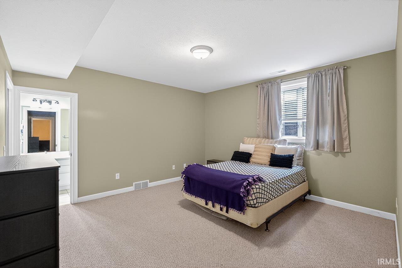 Bedroom with light carpet and baseboards