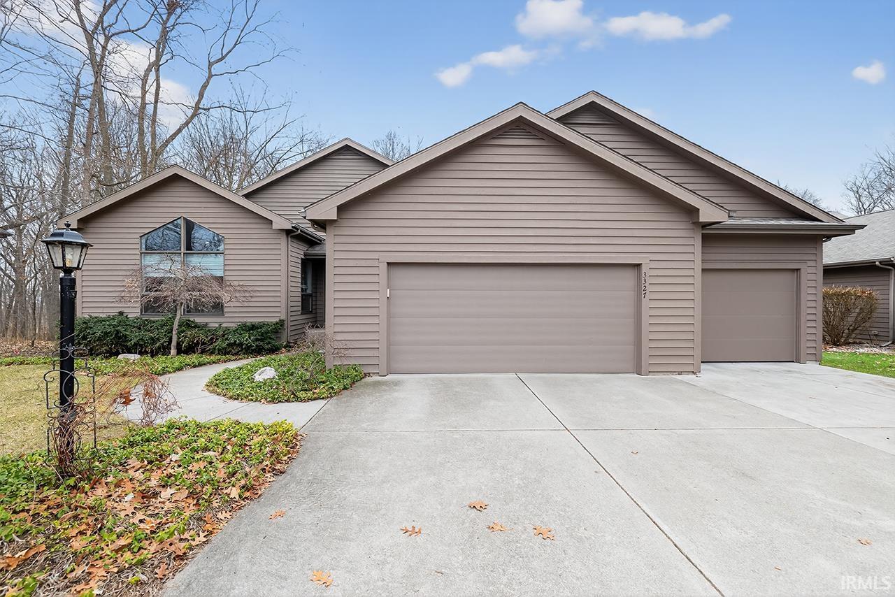Ranch-style home featuring an attached garage and driveway