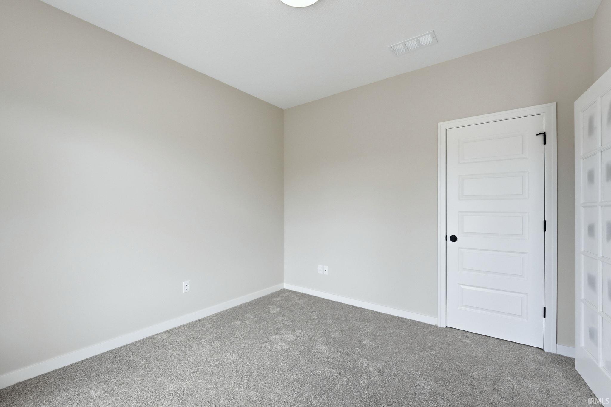 Carpeted spare room with baseboards