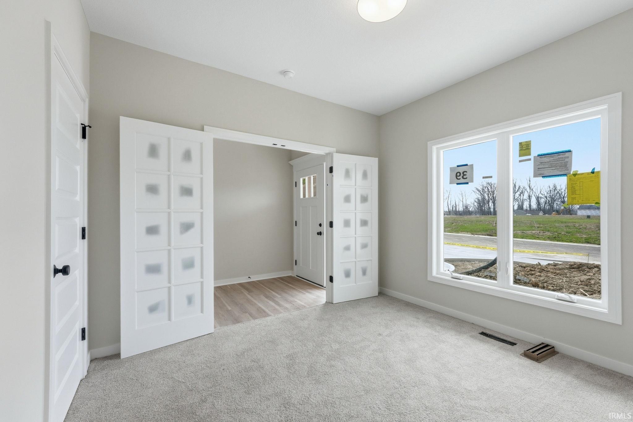 Unfurnished bedroom featuring light colored carpet and baseboards