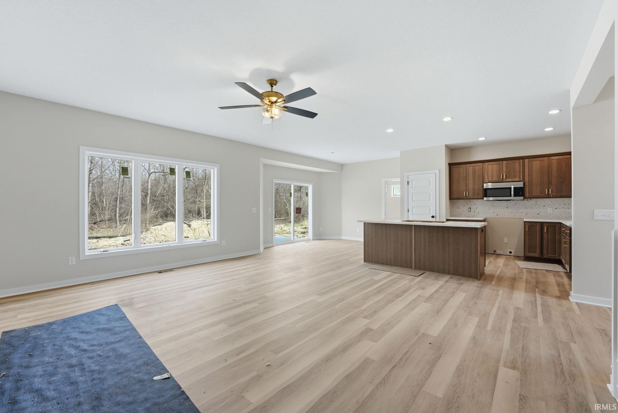 Unfurnished living room with light wood finished floors, ceiling fan, and recessed lighting