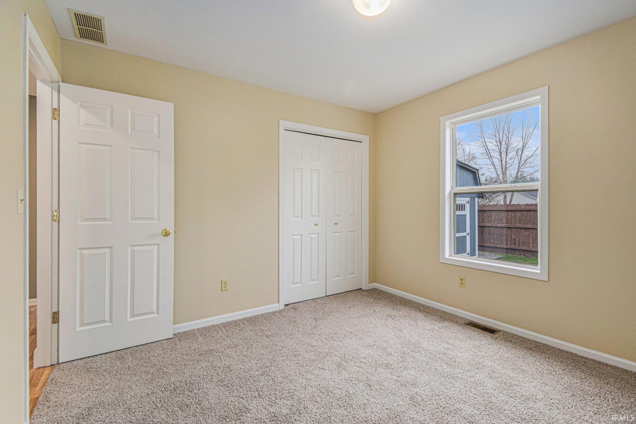 Unfurnished bedroom with a closet and light colored carpet
