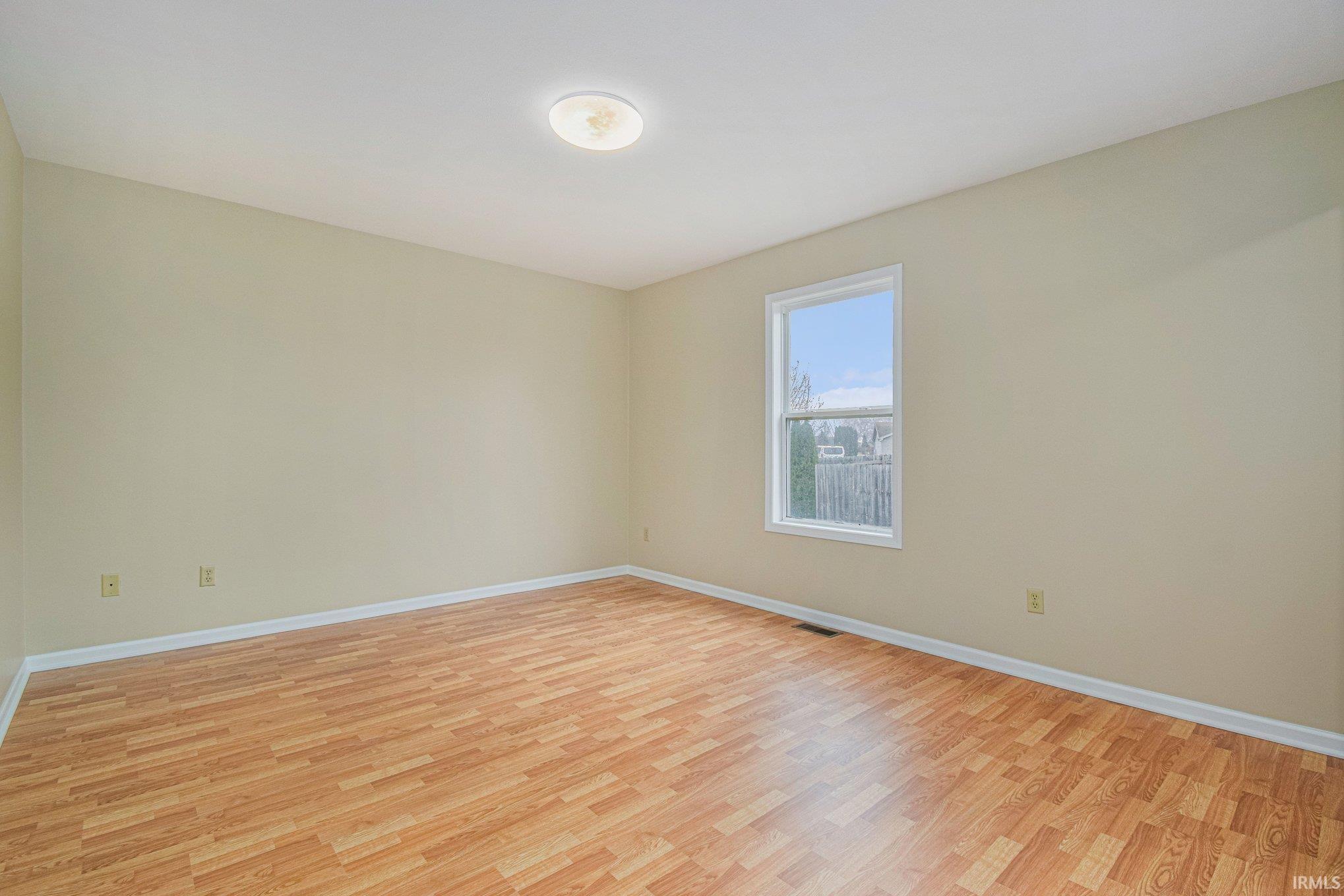 Empty room with light wood-style floors and baseboards