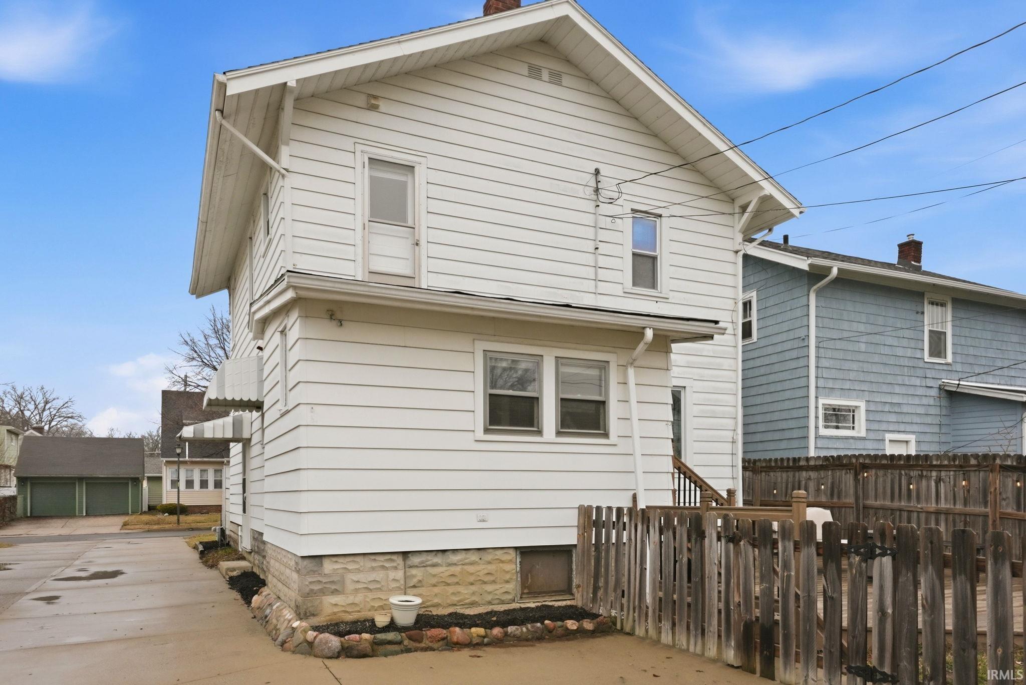 Rear view of property with a detached garage and a chimney