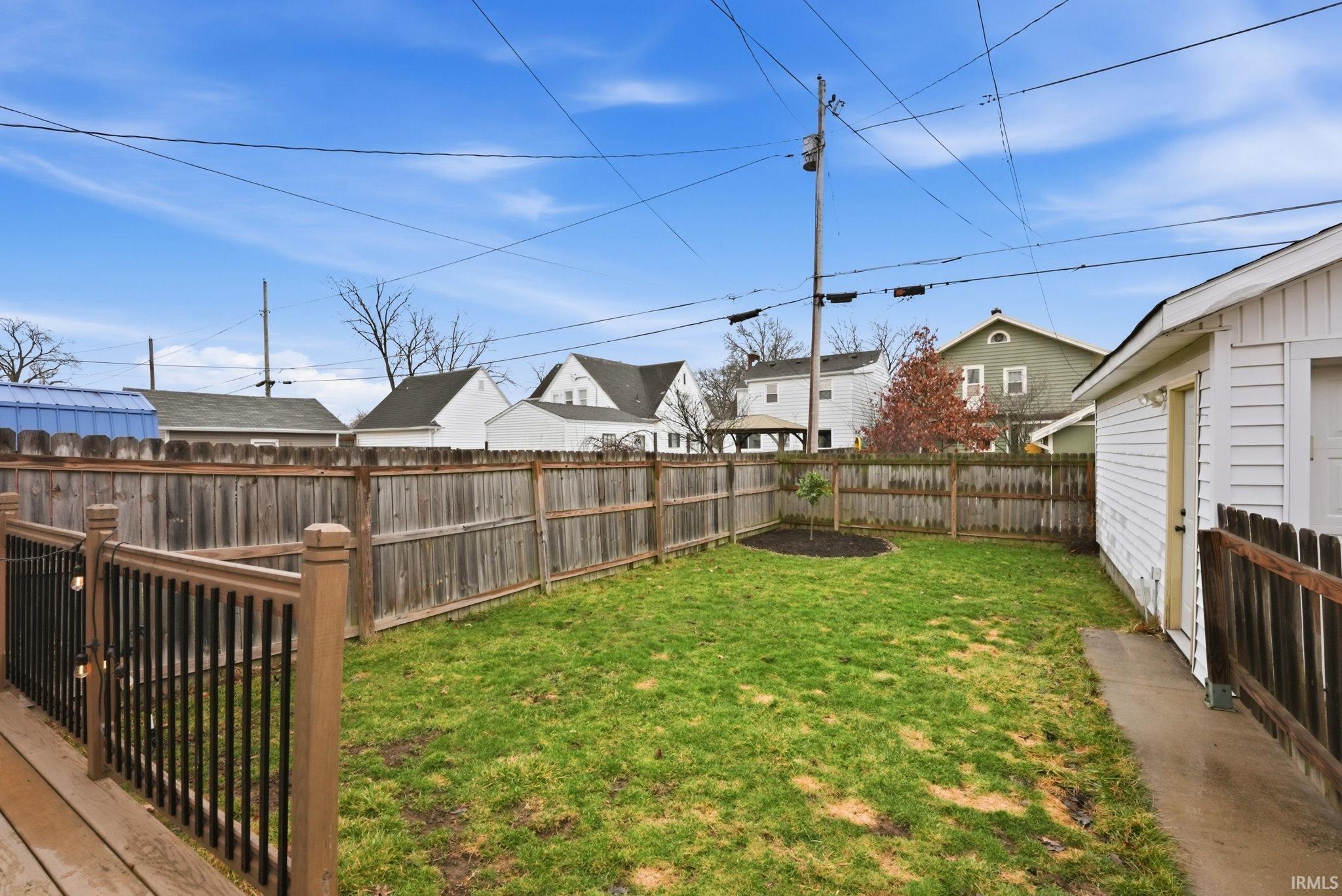 Fenced backyard featuring a residential view