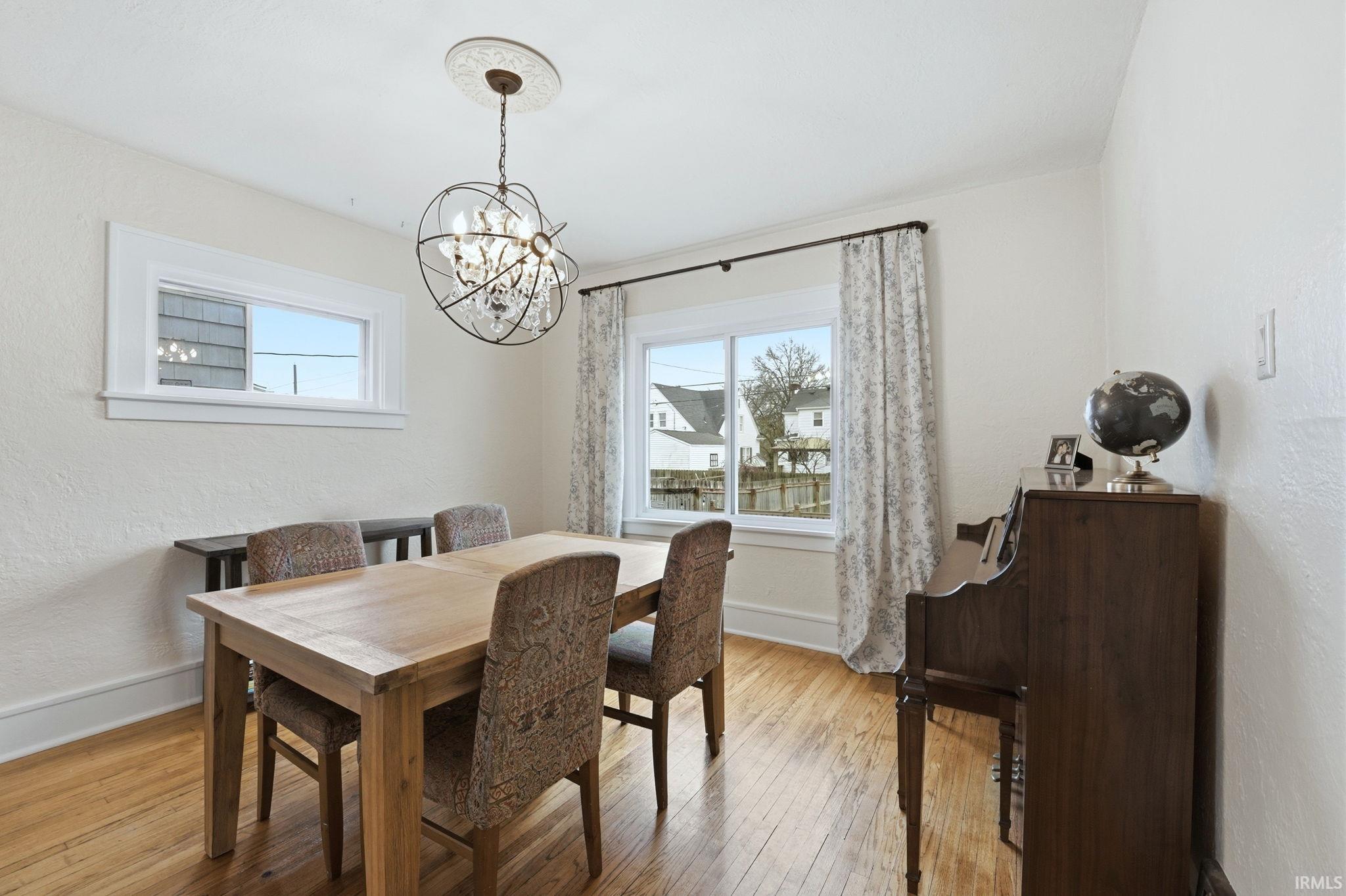 Dining area featuring a textured wall, a chandelier, and light wood-style flooring