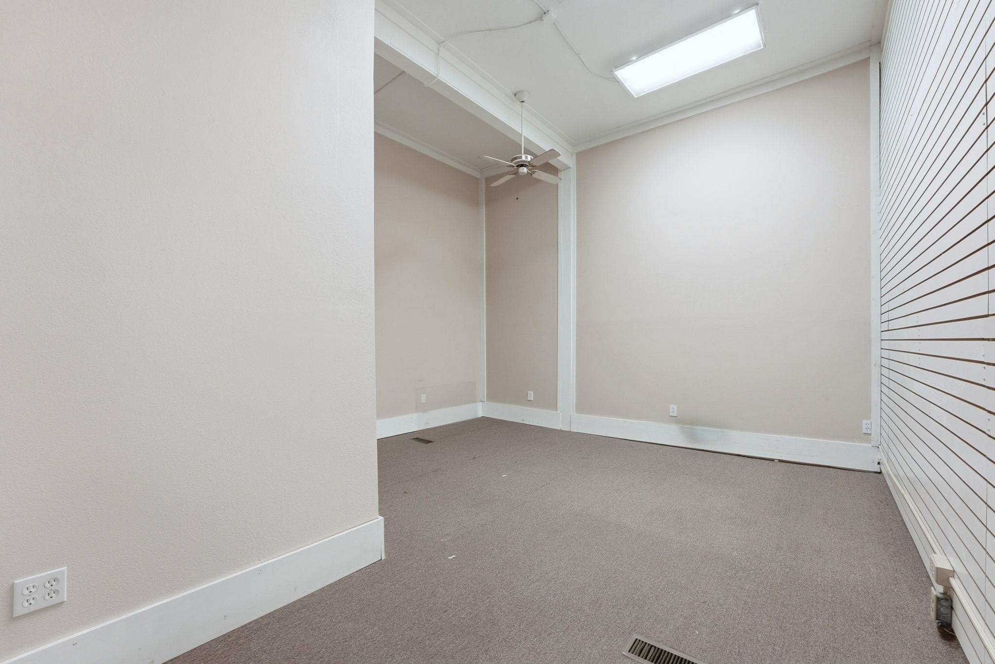Empty room featuring light colored carpet, a ceiling fan, and crown molding