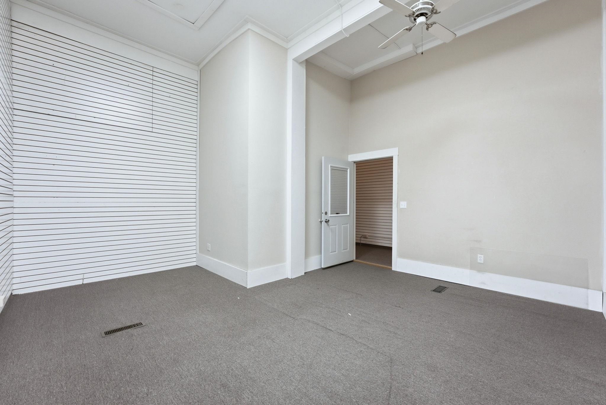 Carpeted spare room featuring a high ceiling, ceiling fan, and crown molding