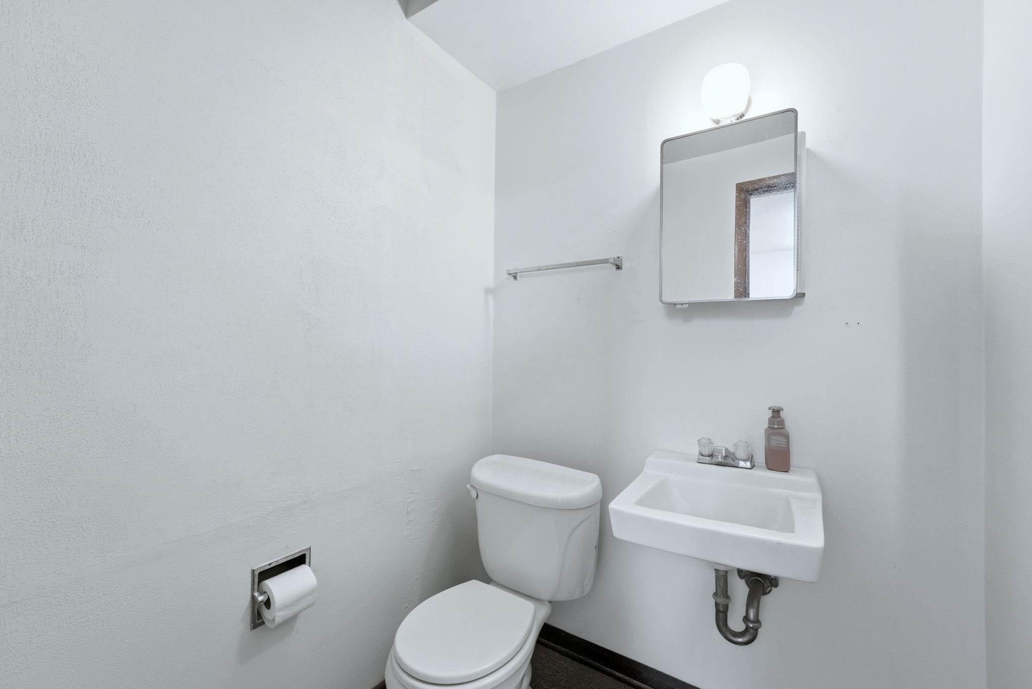 Half bath featuring toilet and a sink