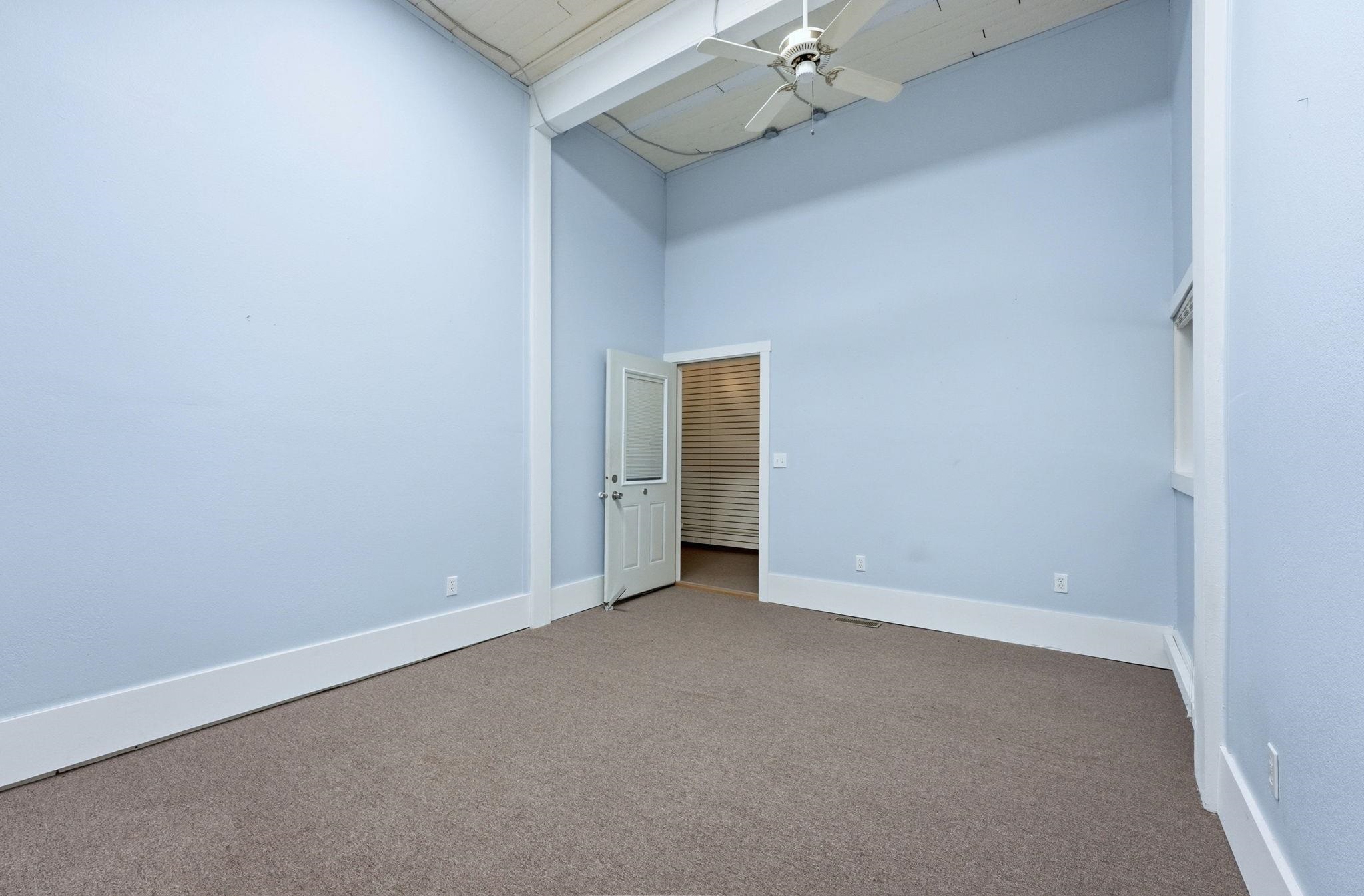 Spare room with a high ceiling, carpet, and a ceiling fan