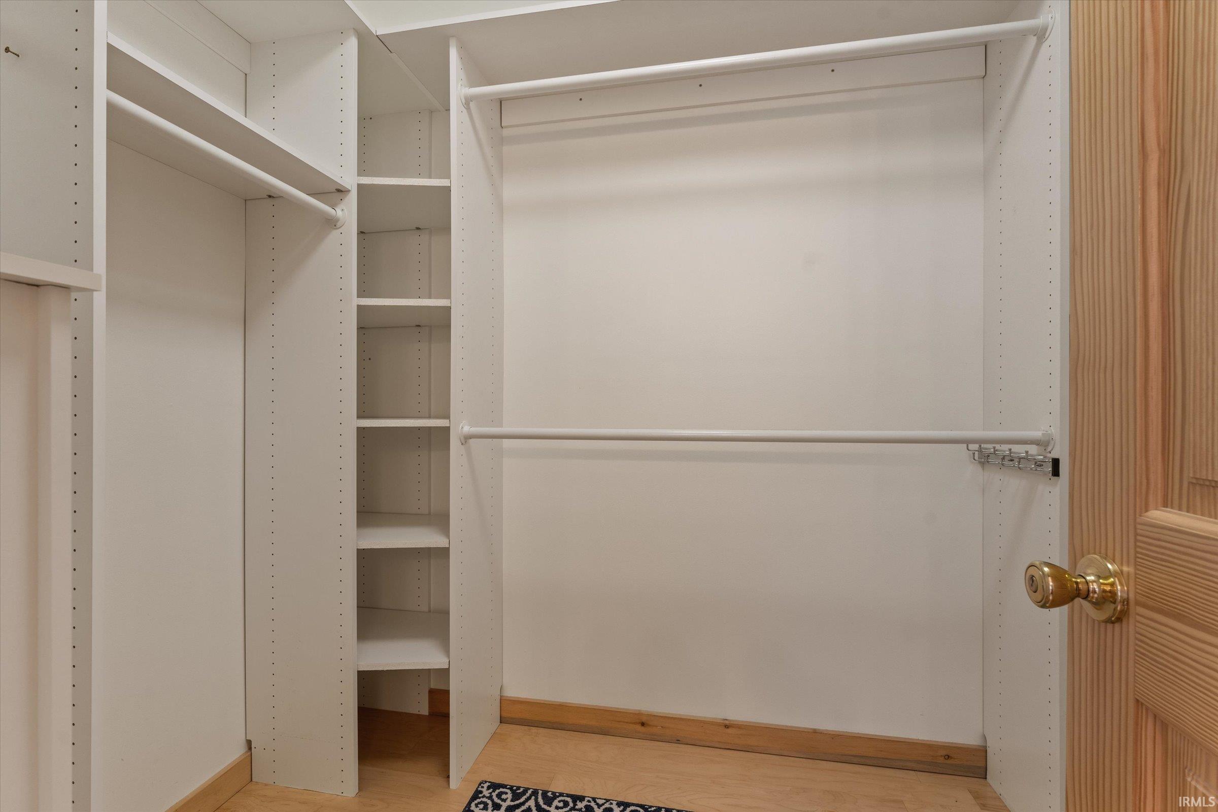 Walk in closet with light wood-style floors
