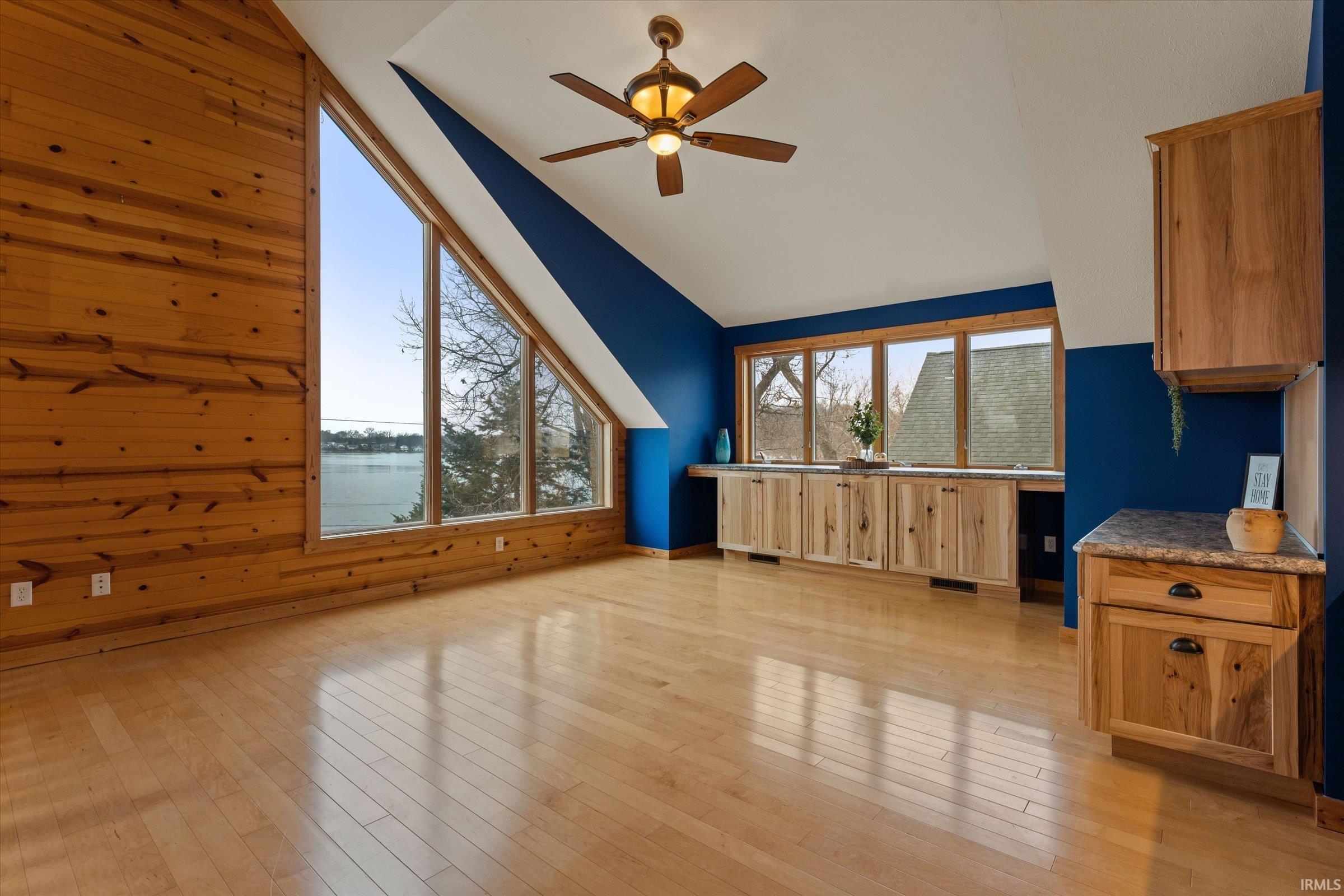 Bonus room with ceiling fan, light wood finished floors, a water view, and vaulted ceiling