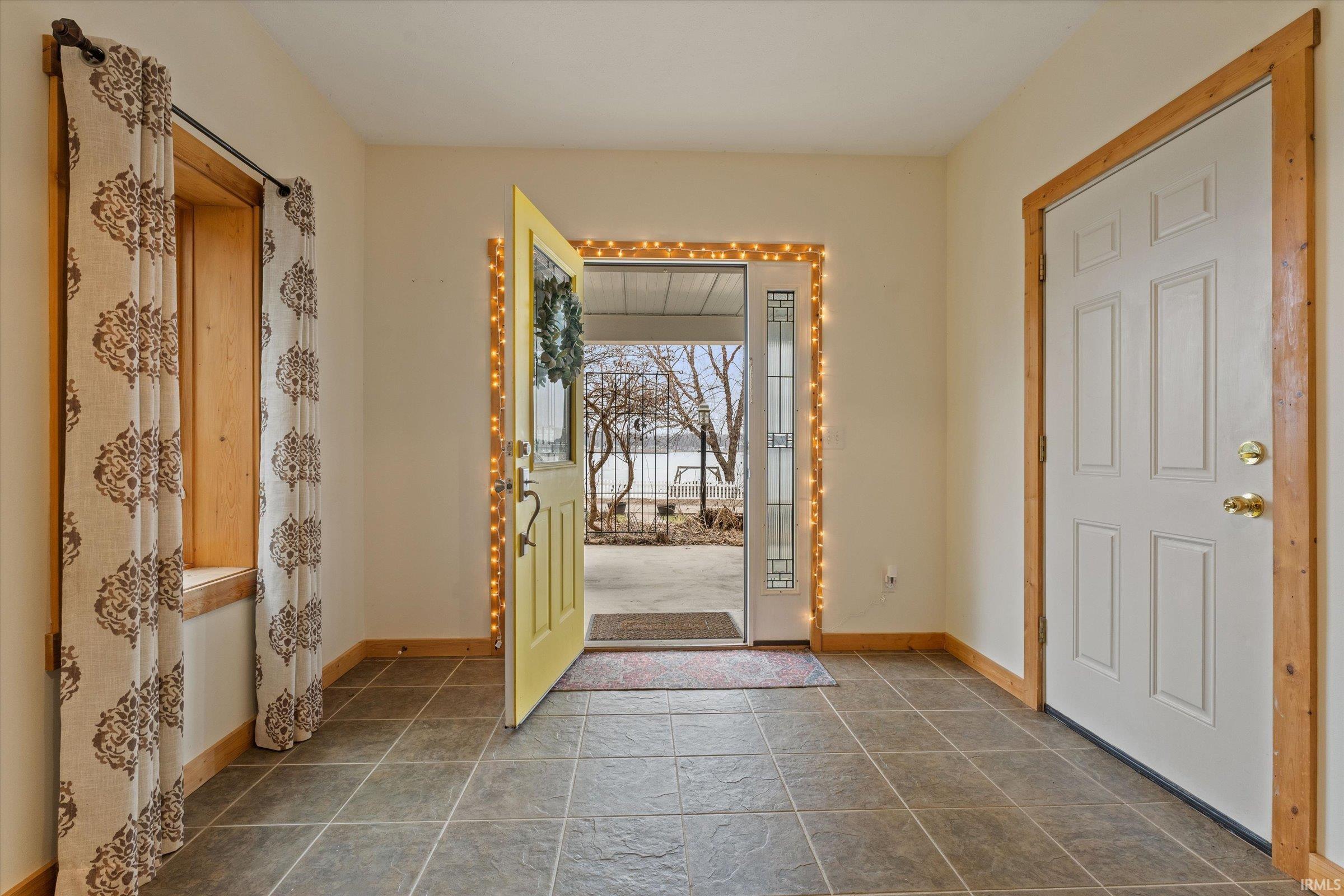 Foyer with baseboards and dark stone finish flooring