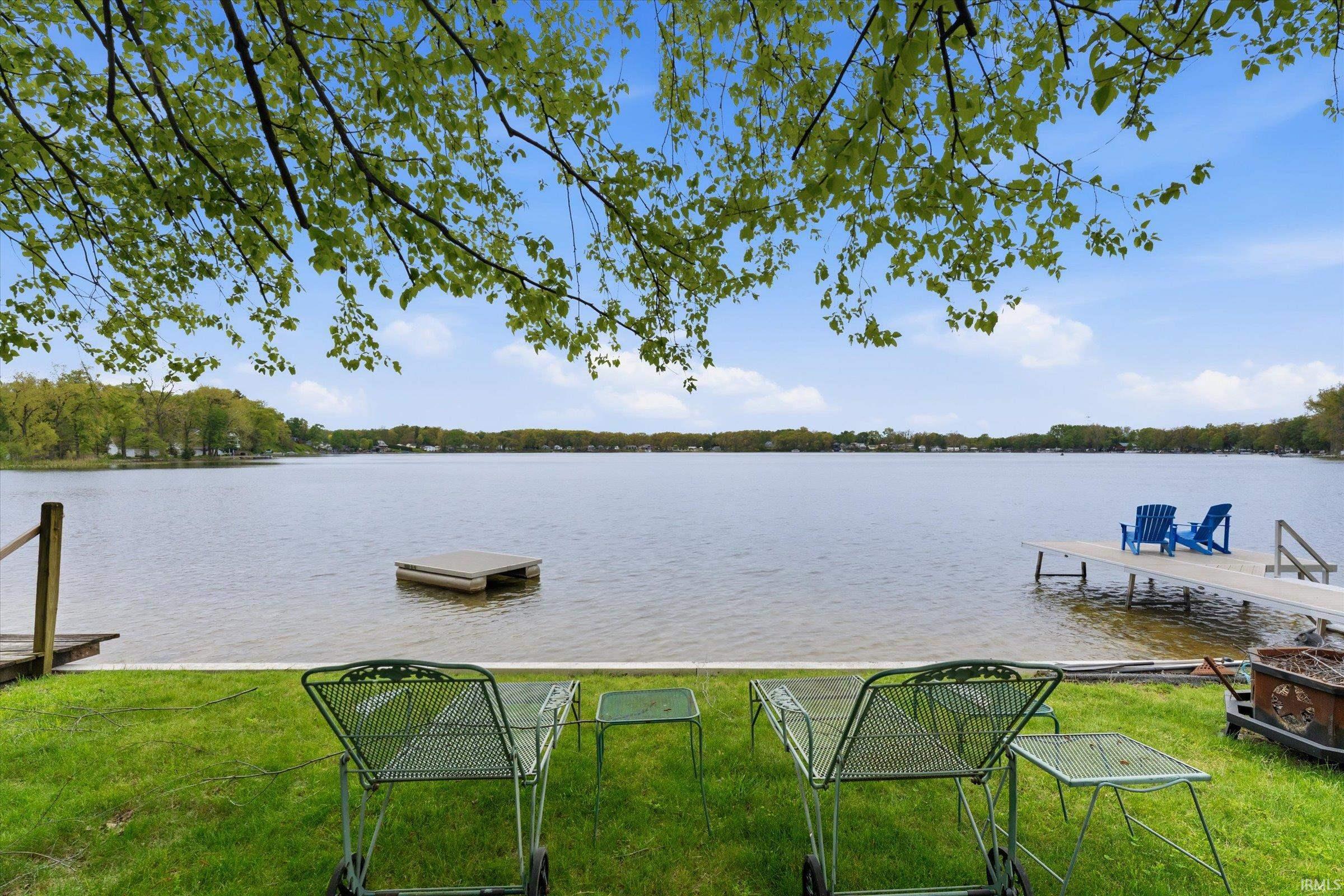 Expansive waterfront property featuring a private dock, a separate floating dock, and a verdant lawn