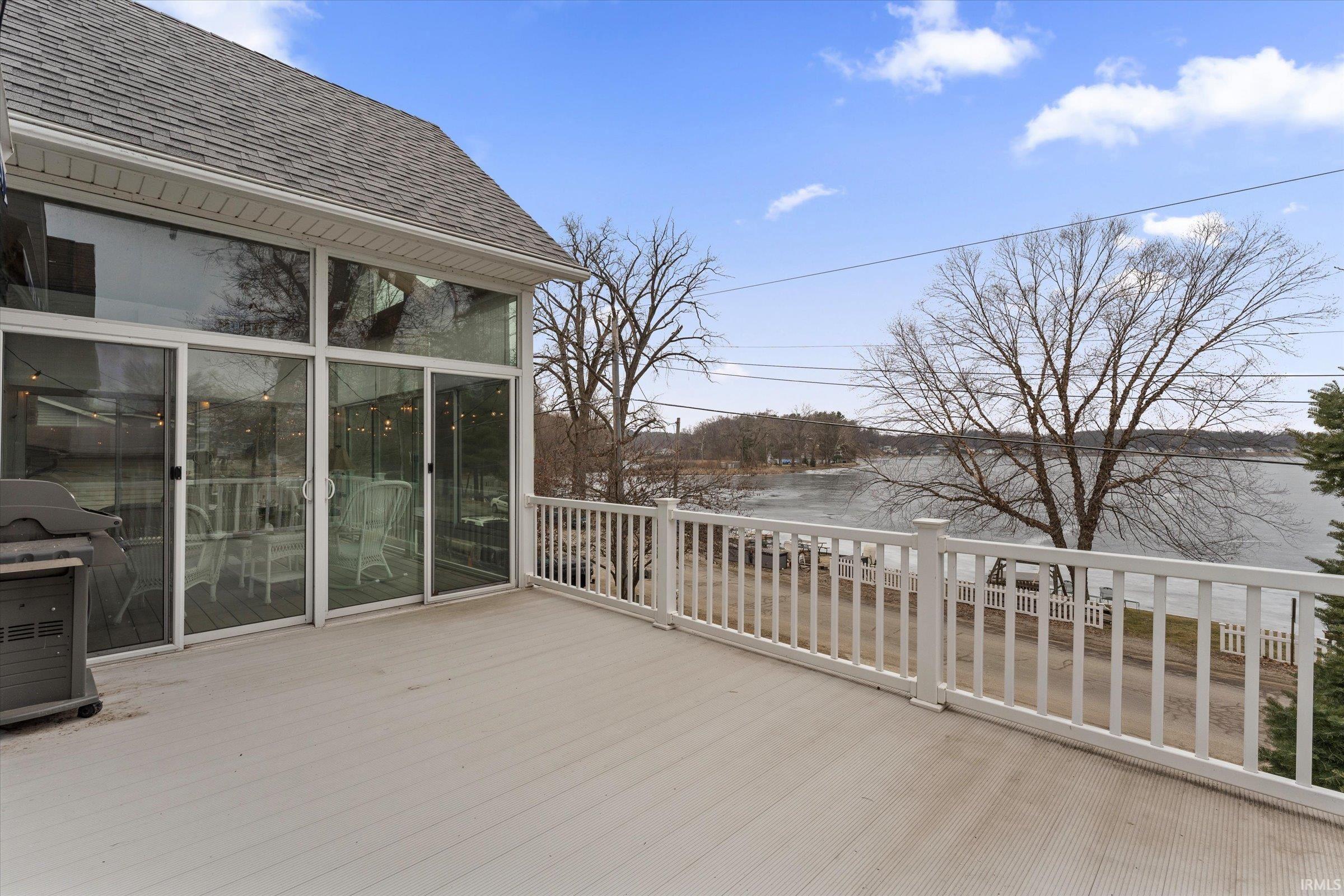 Wooden terrace featuring a sunroom and grilling area