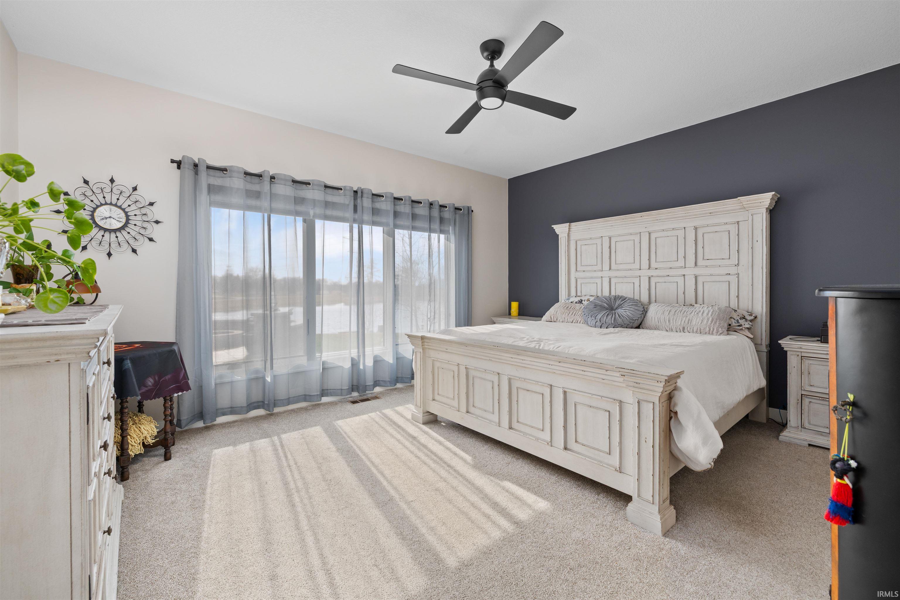 Bedroom with light carpet and ceiling fan