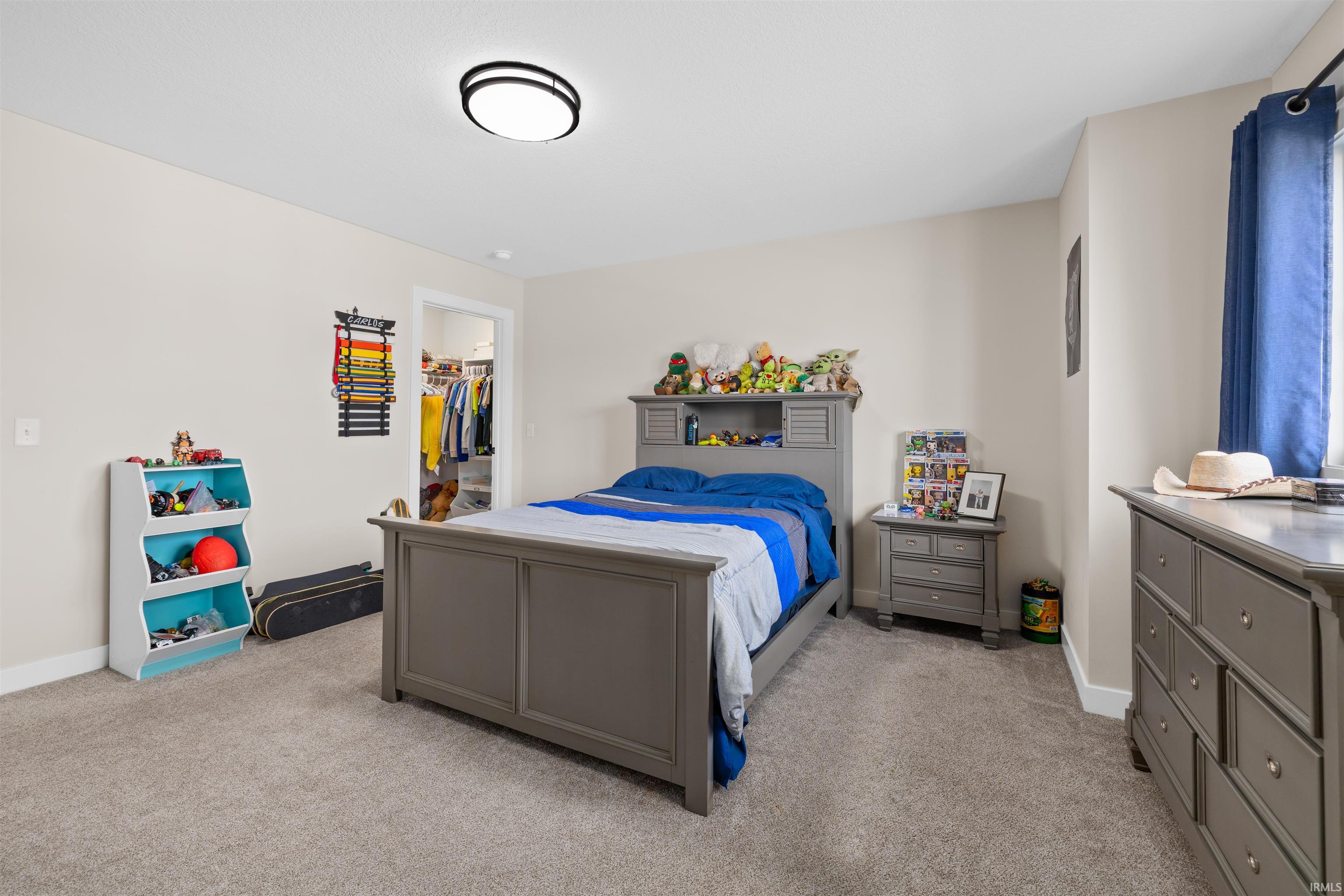 Bedroom featuring a spacious closet and light colored carpet