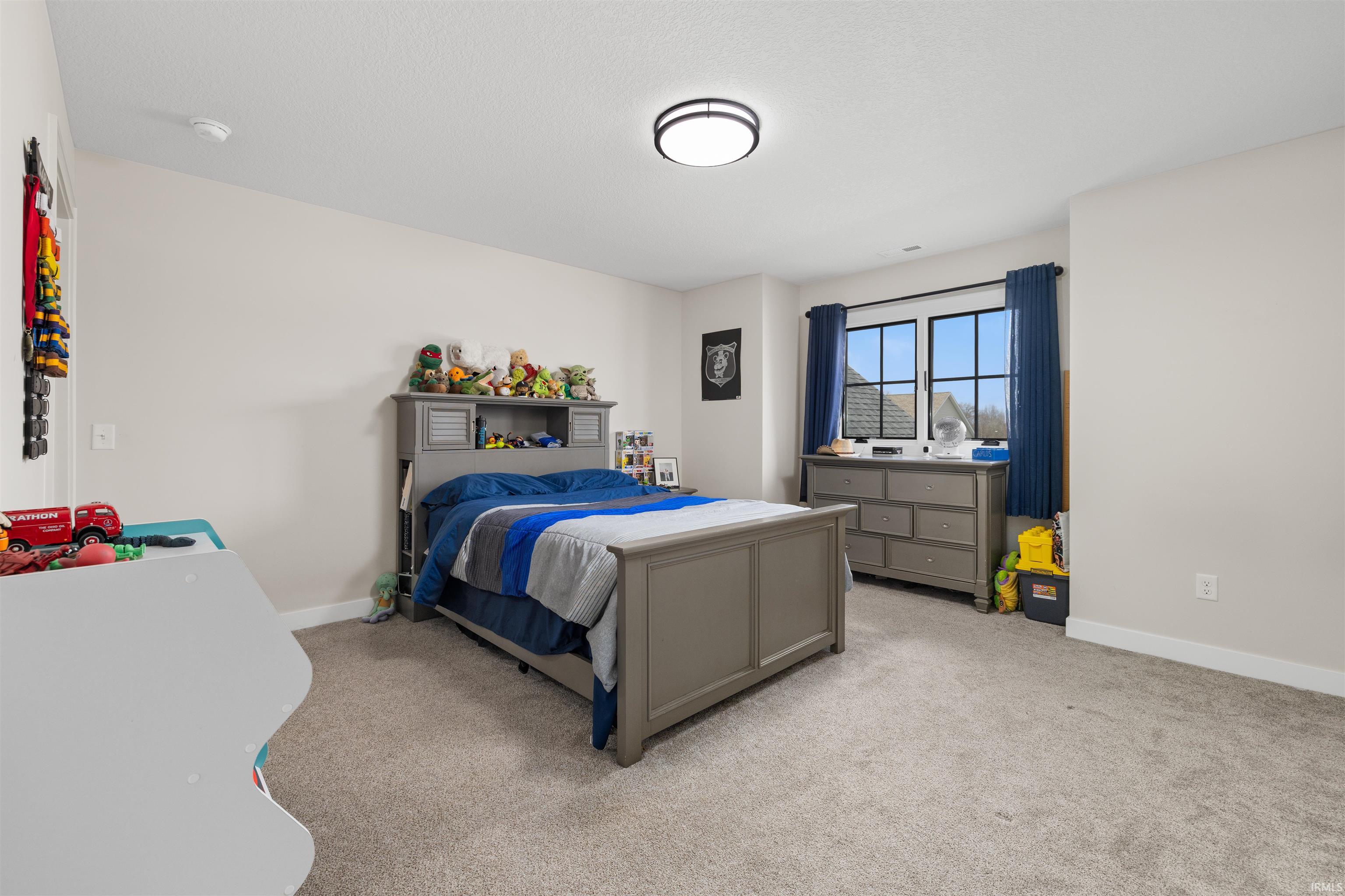 Bedroom with baseboards and light carpet