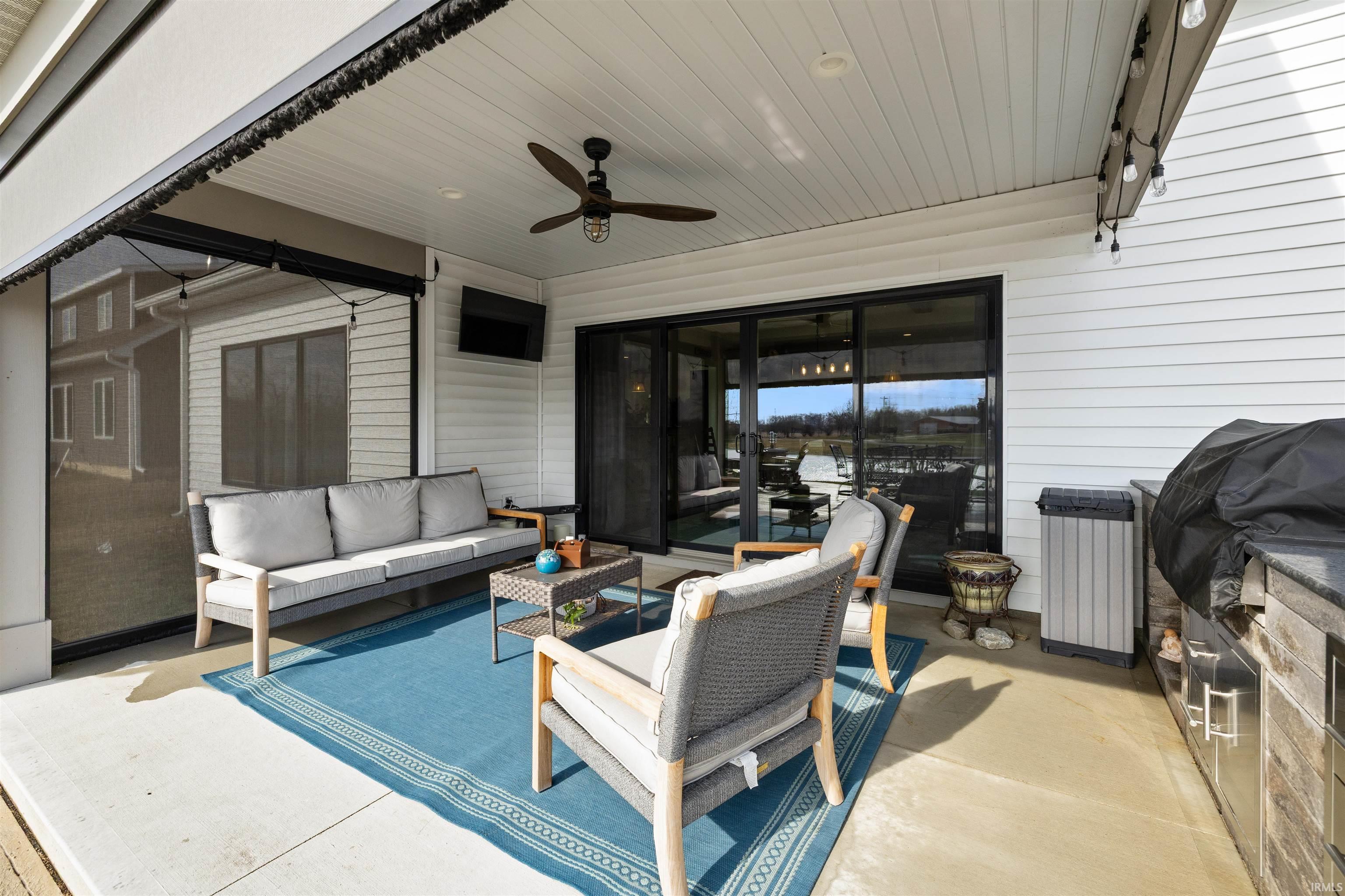 View of patio with ceiling fan, area for grilling, and outdoor seating
