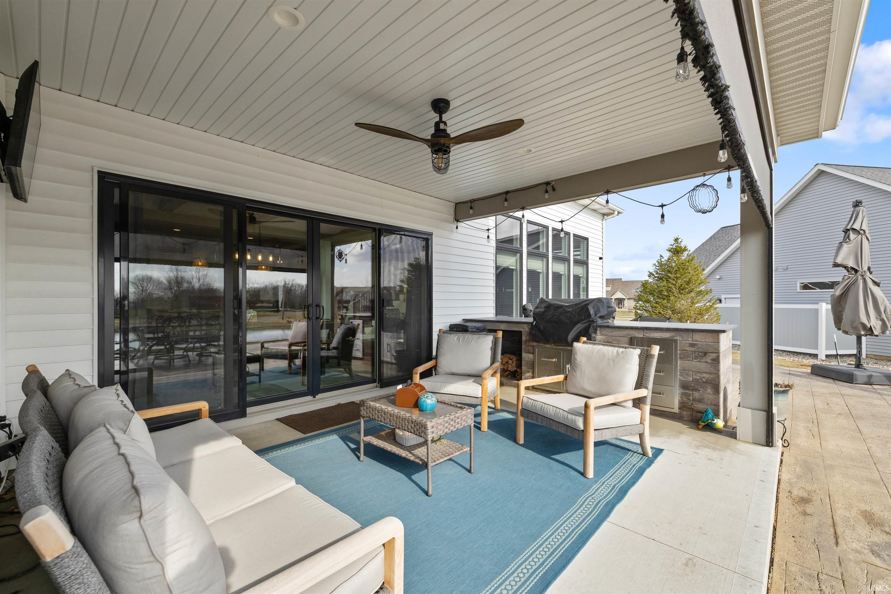 View of patio with an outdoor kitchen and area to lounge and ceiling fan