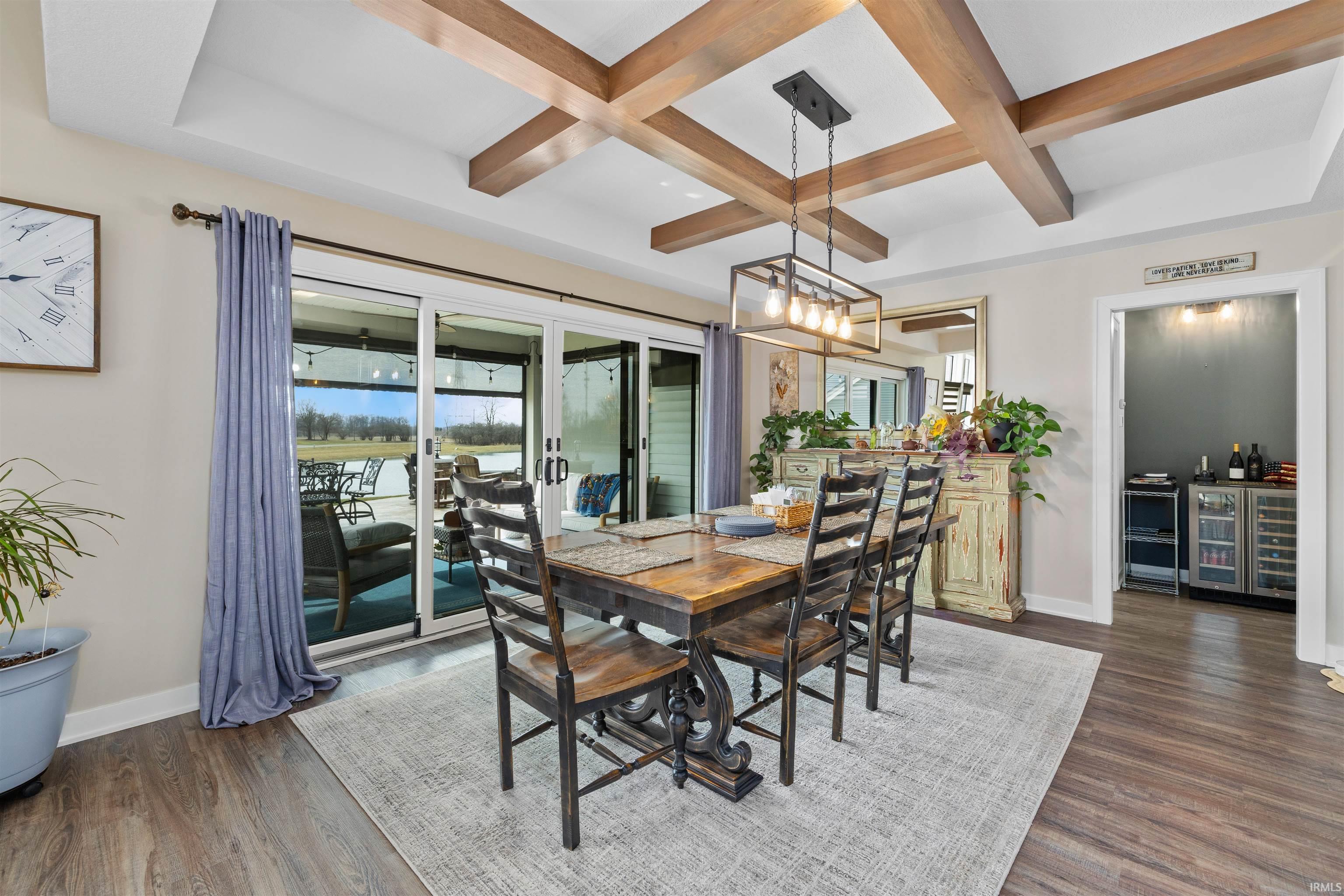 Dining space featuring coffered ceiling, beverage cooler, and dark wood-style floors