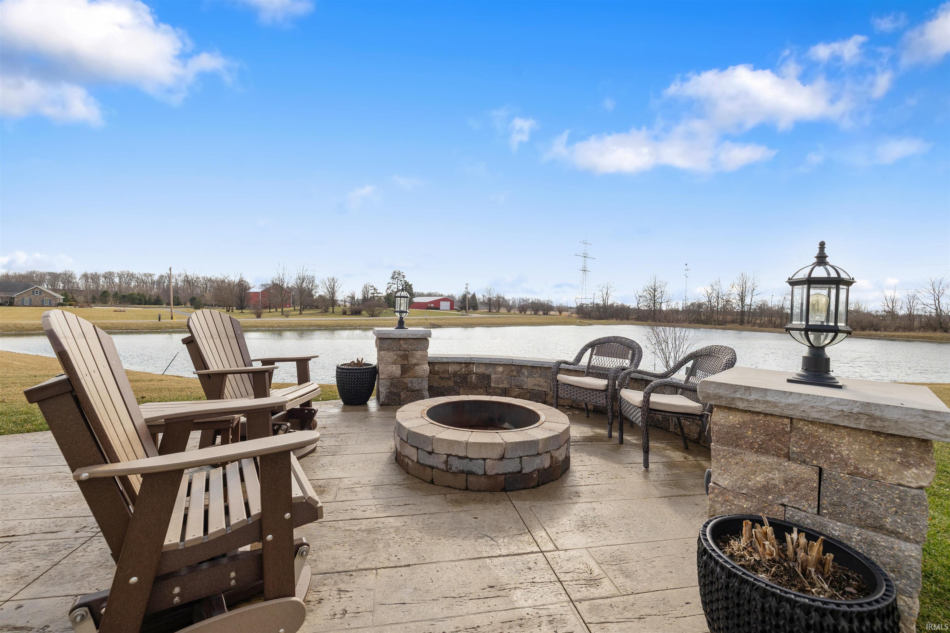 View of patio with an outdoor fire pit and a water view