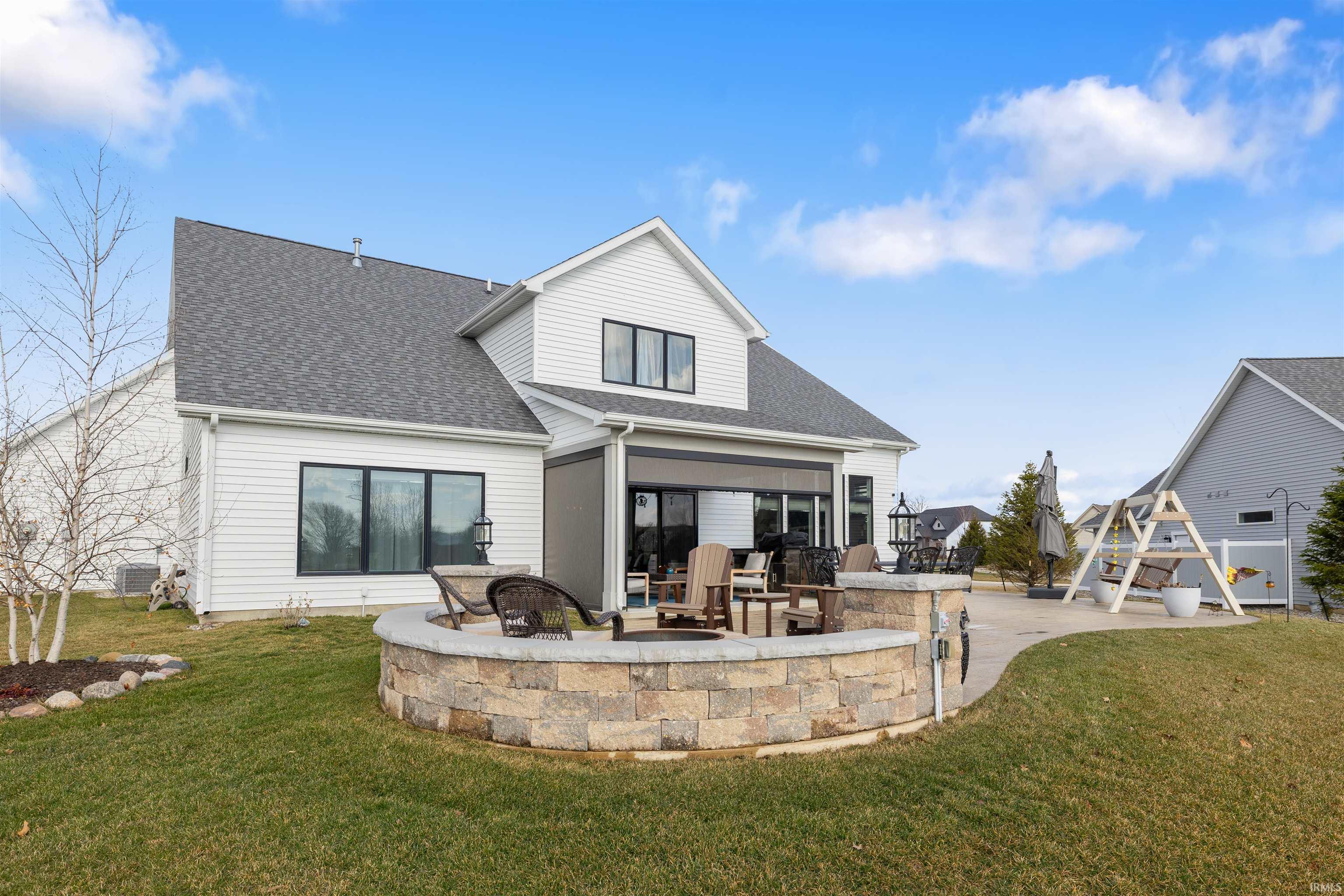 Rear view of property with a patio, a shingled roof, and a yard