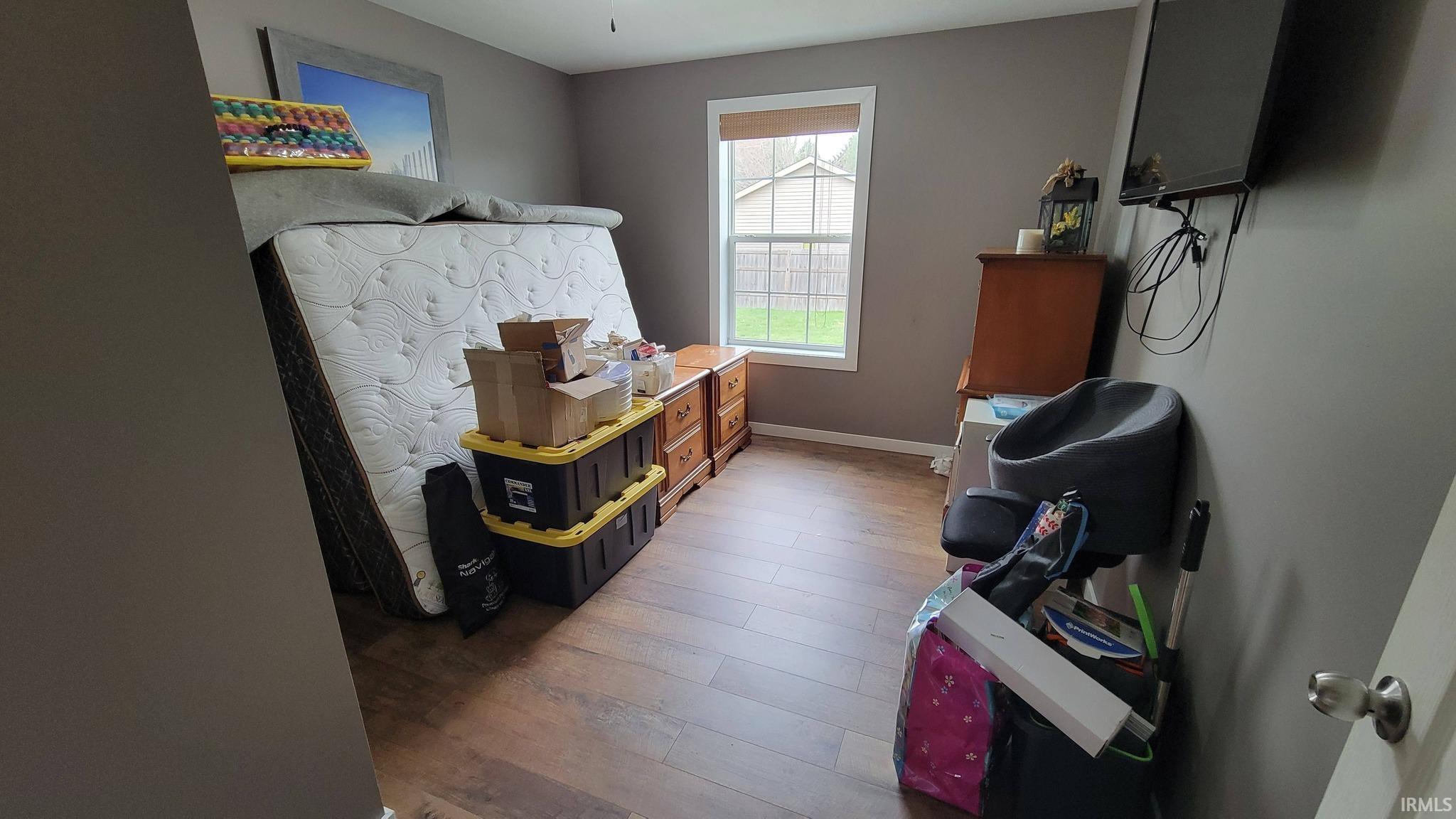 Bedroom featuring dark wood finished floors and baseboards