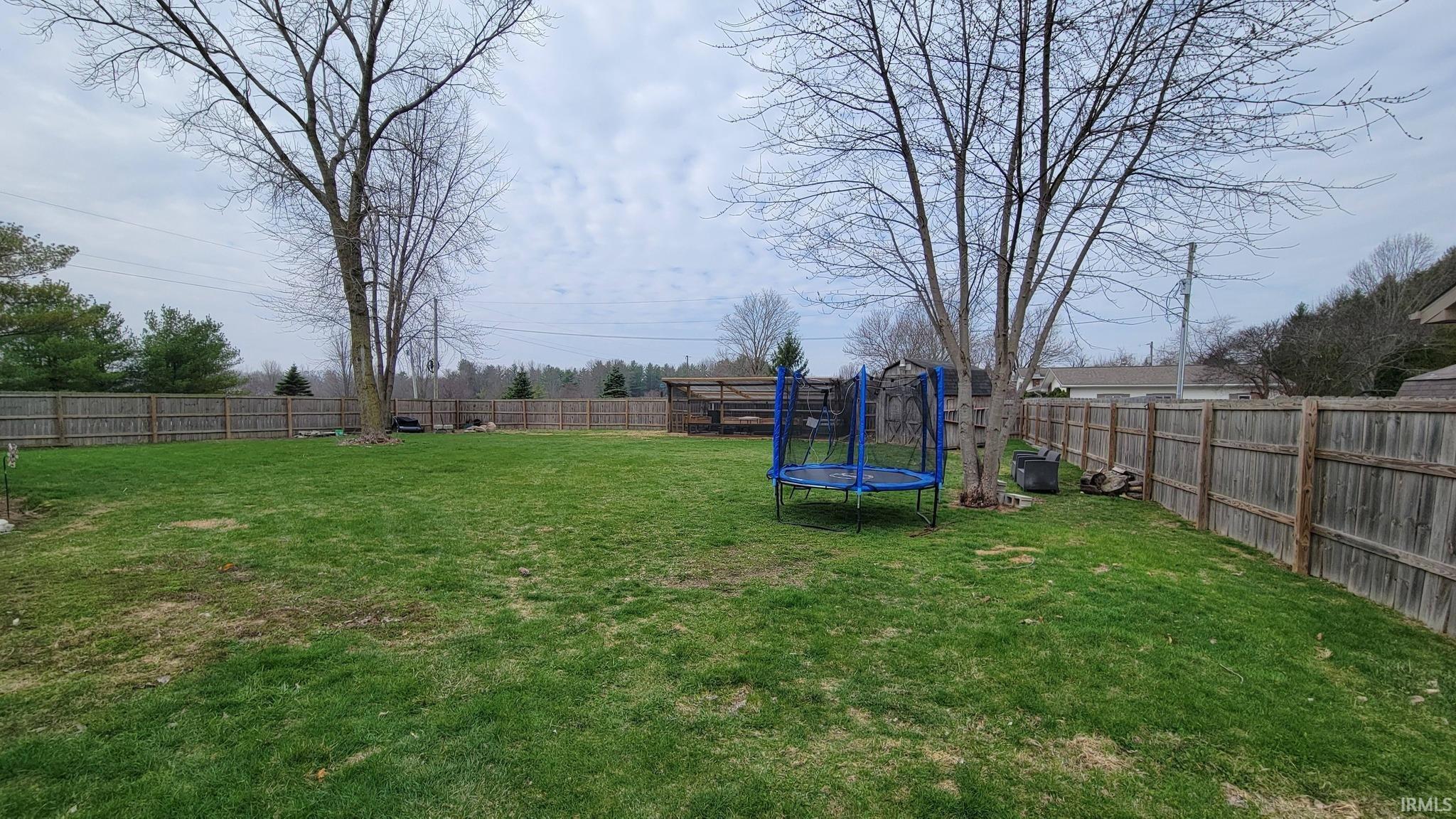 Fenced backyard with a trampoline