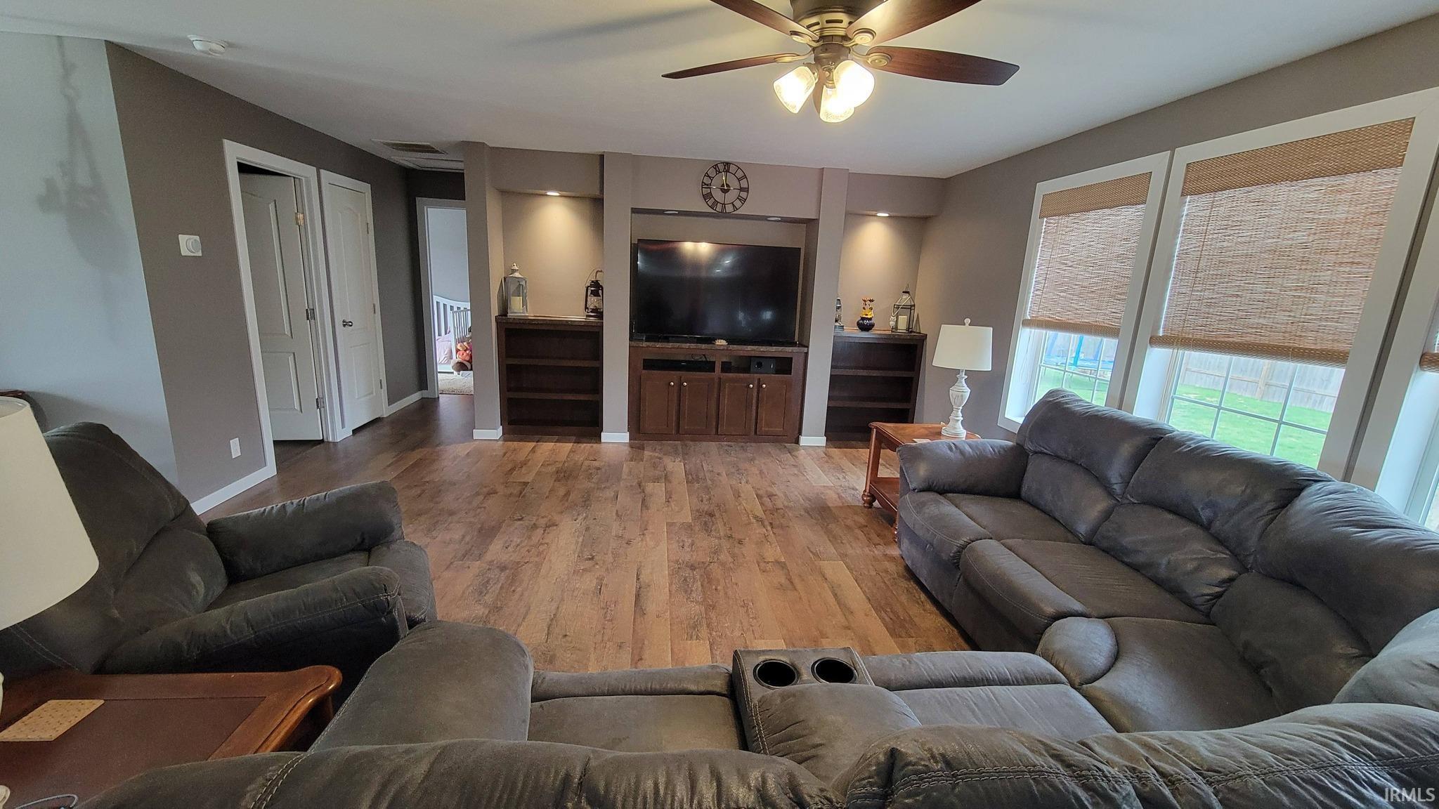 Living area featuring light wood finished floors and a ceiling fan