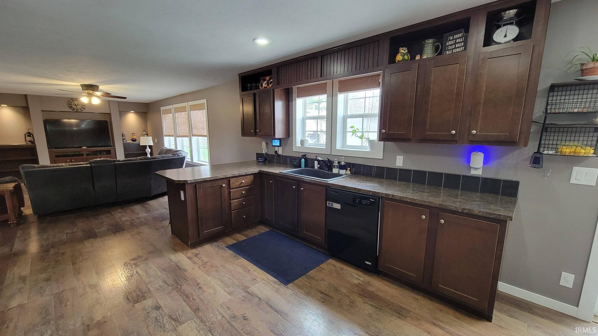 Kitchen featuring dark wood finish cabinets, open shelves, and a peninsula